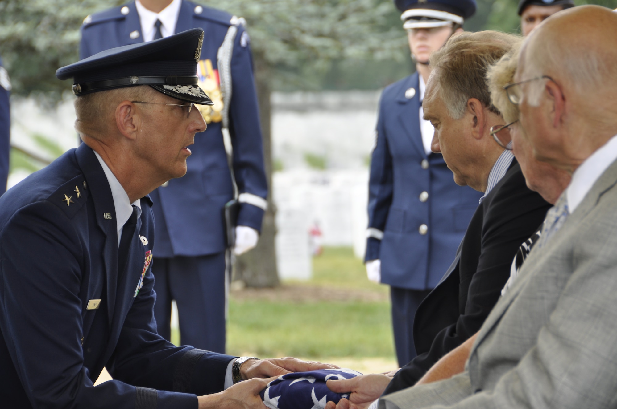 Maj. Gen. Duane A.  Jones, director of Resource Integration, Office of the Deputy Chief of Staff for Logistics, Installations and Mission Support, Headquarters U.S. Air Force Washington, presents the U.S. flag to Joan Bergsteinsson and Alan Brink, cousins of missing in action servicemember Maj. Richard G. Elzinga, July 8, 2011 at Arlington National Cemetery, Va. Elzinga is repatriated at a graveside inurnment service where members of the Bolling Air Force Base Honor Guard render military funeral honors. (U.S. Air Force photo/Capt. Pamela Stauffer)