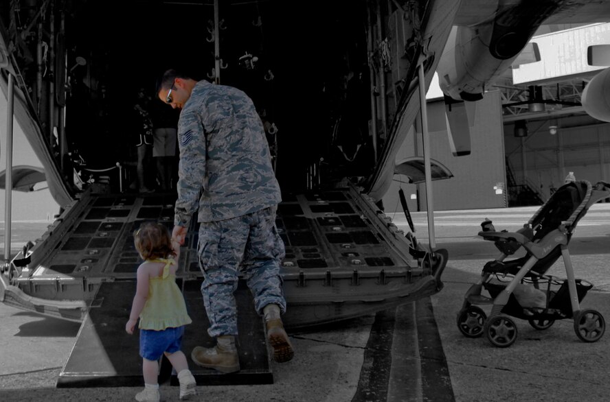 Tech.  Sgt. Donald Bair, 32nd Aerial Port Squadron loadmaster, walks up the ramp of a C-130 with his daughter during the annual family day picnic. The picnic offered a chance for family members of 911th Airlift Wing Airmen to see the base while taking part in various activities such as; the dunk tank, rock wall climbing, and pony rides. (U.S. Air Force photo illustration/Senior Airman Joshua J. Seybert)