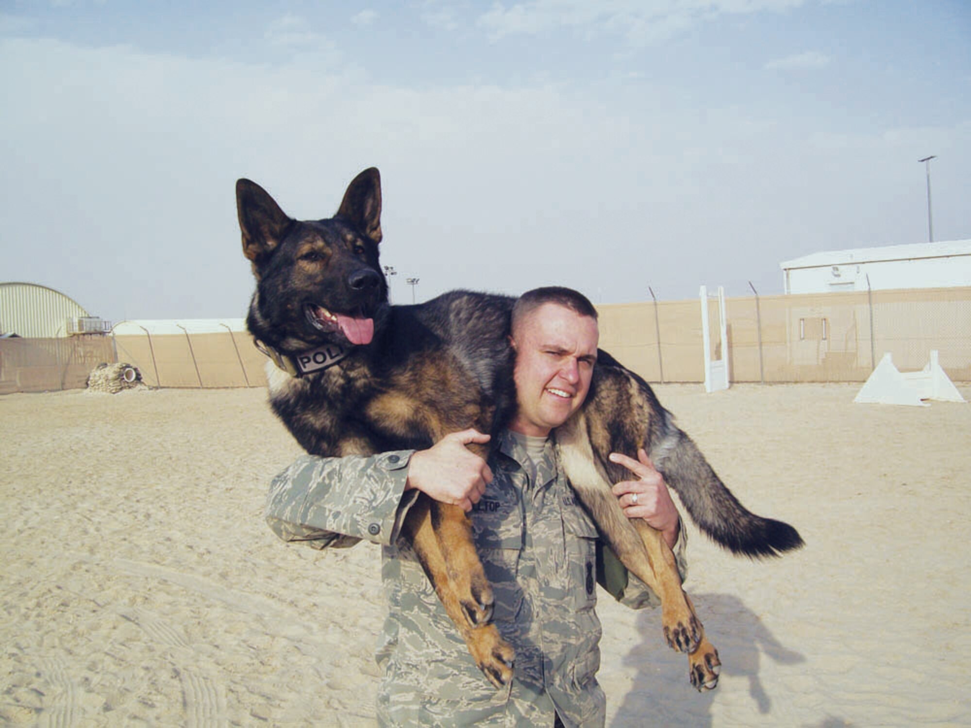 Staff Sgt. Kyle Alltop, 56th Security Forces Squadron military working dog handler, poses for a photo with Chrach, 56th SFS MWD in Kuwait.  (Courtesy photo)