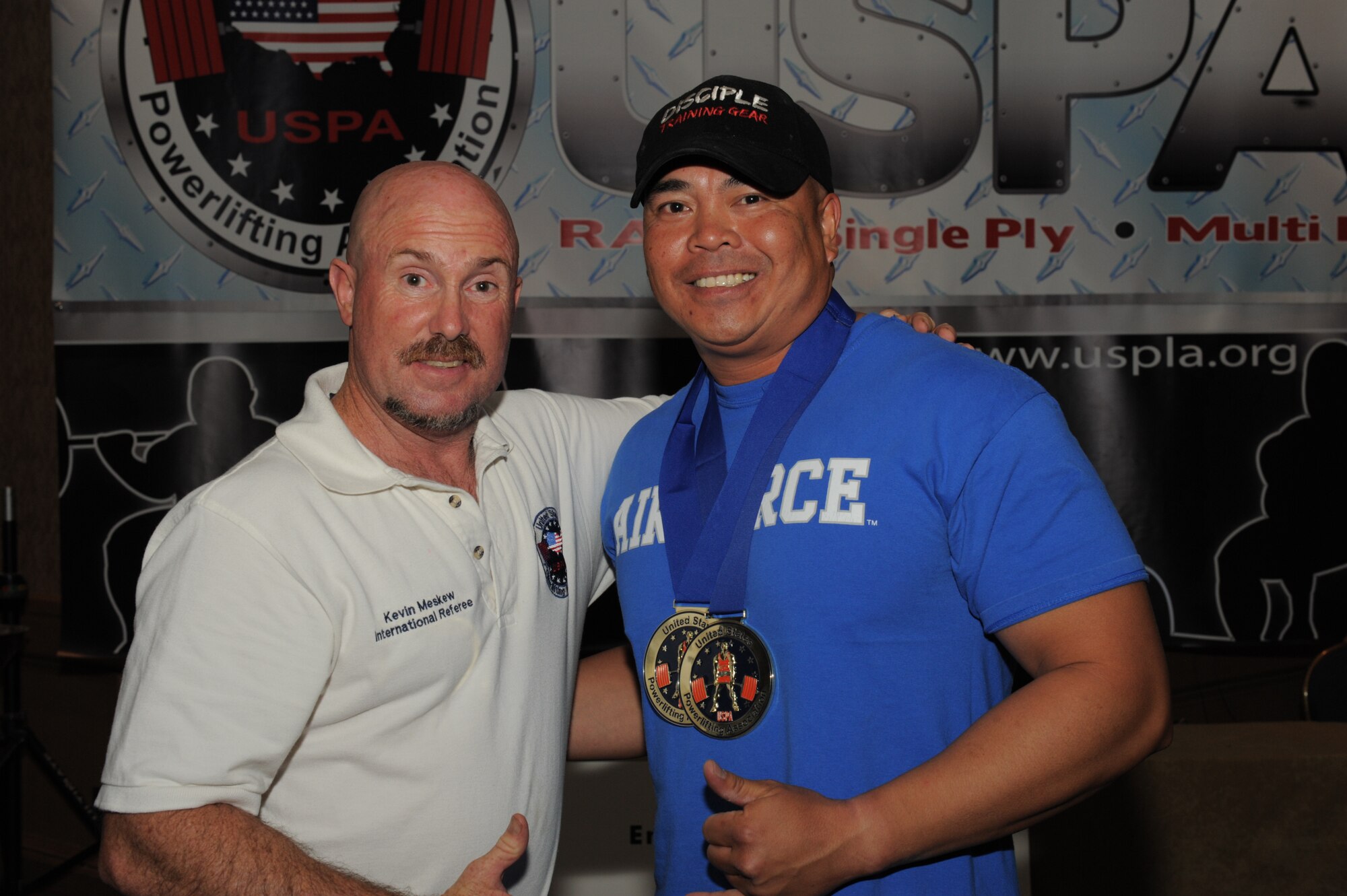 Kevin Meskew, United States Powerlifting Association international official, left, congratulates U.S. Air Force Tech. Sgt. Rudy Garcia, 99th Ground Combat Training Squadron NCO in charge of combat arms, right, for winning first place in both the USPA National and Military National Powerlifting Championships held July 1-3, 2011, in Costa Mesa, Calif.  During the championships, Garcia set a new USPA American record when he squatted 480 pounds while competing in the 181-pound Full Power Submaster Division for 35- to 39-year-olds.  (Courtesy Photo)