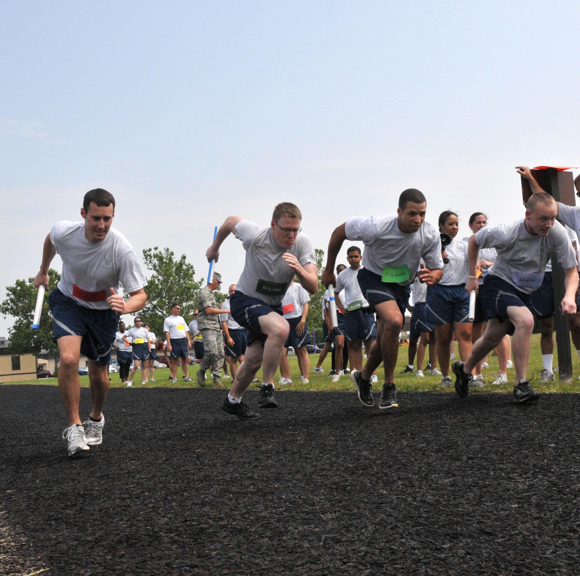 Officers and enlisted members of the 512th Airlift Wing take off with relay-race batons June 12, 2011, as part of the wing's fitness challenge at the base track. The wing will host another fitness event, a 5K Run, Walk or Crawl, Aug. 6, 2011, at the fitness center. (U.S. Air Force photo by Staff Sgt. Andria J. Allmond/Released()