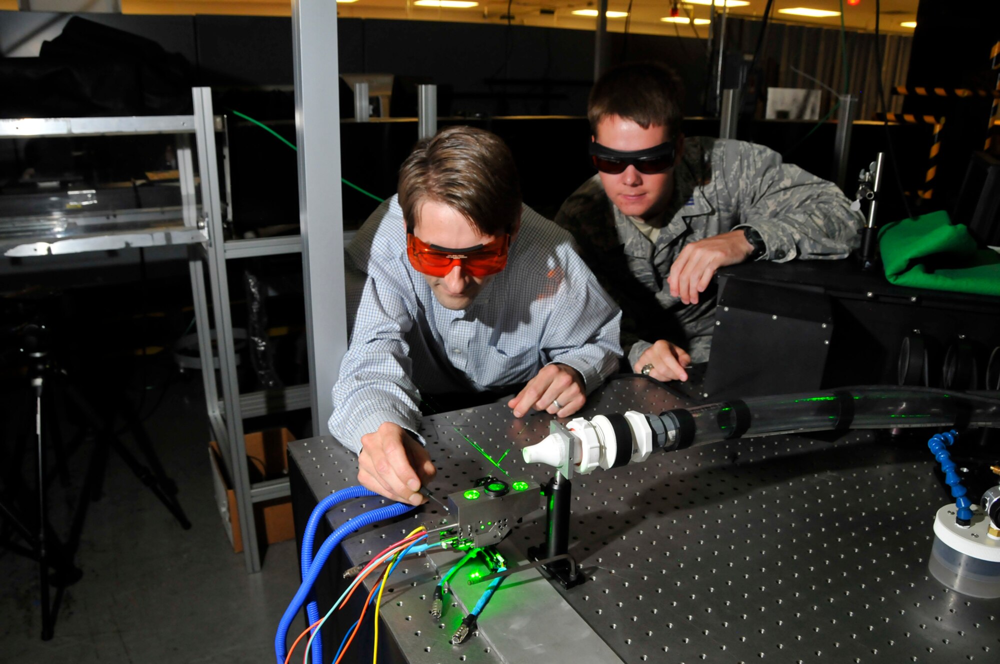 From left, Applied University Research, Inc., Vice President for research and development, Dr. Todd Lowe, and Air Force Academy Cadet 1st Class Andrew Petry, inspect a sub-miniature three component laser-Doppler velocimetry (SM3 LDV) system before it was installed in a small wind tunnel for a test at AEDC. (Photo by Rick Goodfriend)