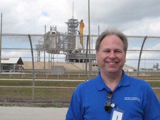 Peter Montgomery poses for a photo Feb. 6, 2010, in fron of the space shuttle Endeavour before its launch for mission STS-130.