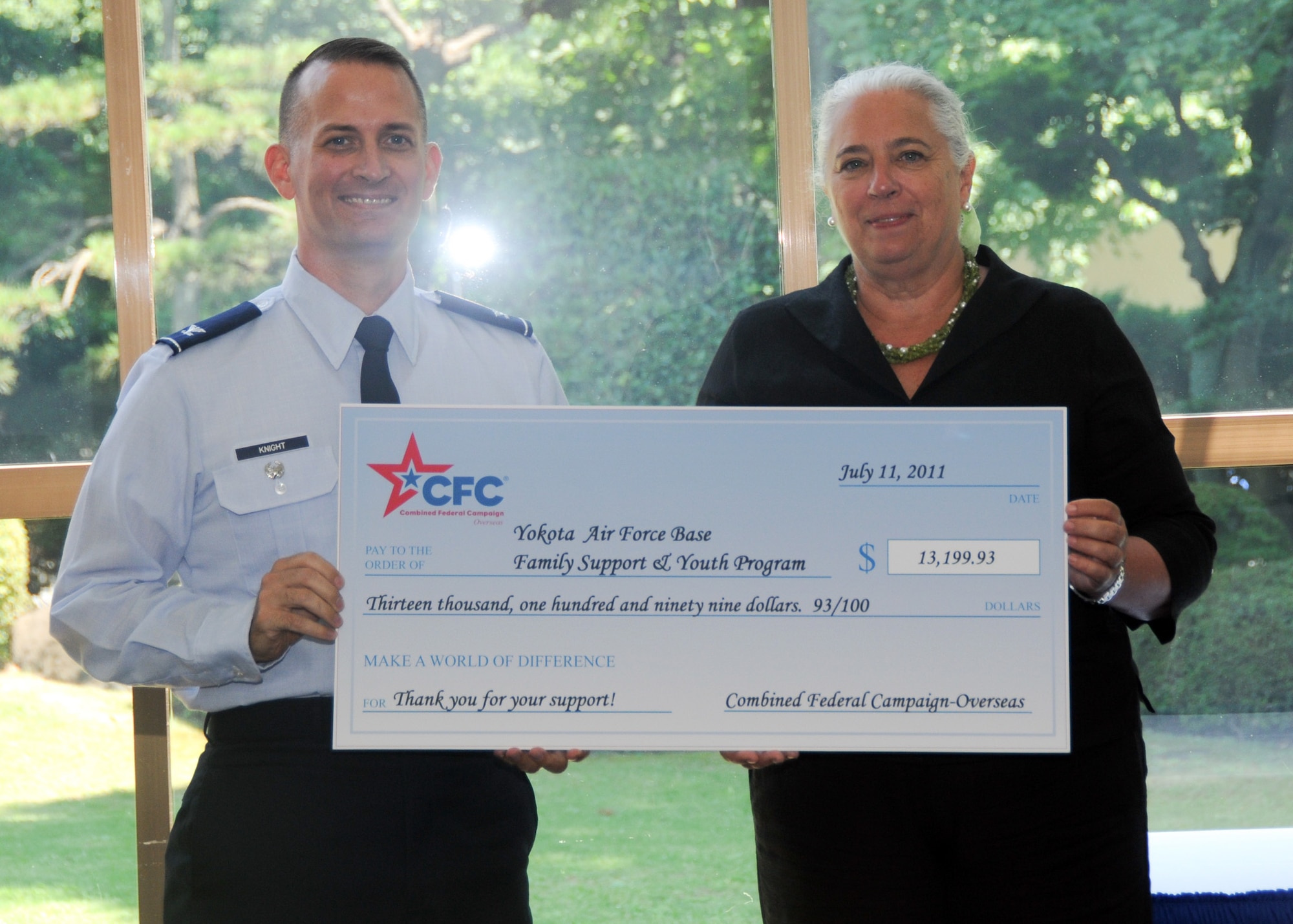 YOKOTA AIR BASE, Japan -- Col. Bill Knight, 374th Airlift Wing vice commander, accepts a check on behalf of the Yokota community for family support and youth programs from the Combined Federal Campaign at Yokota Air Base, Japan, July 11, 2011. Overall, Yokota raised more than $291,000 for the CFC. (U.S. Air Force photo/Airman 1st Class Krystal M. Garrett)
