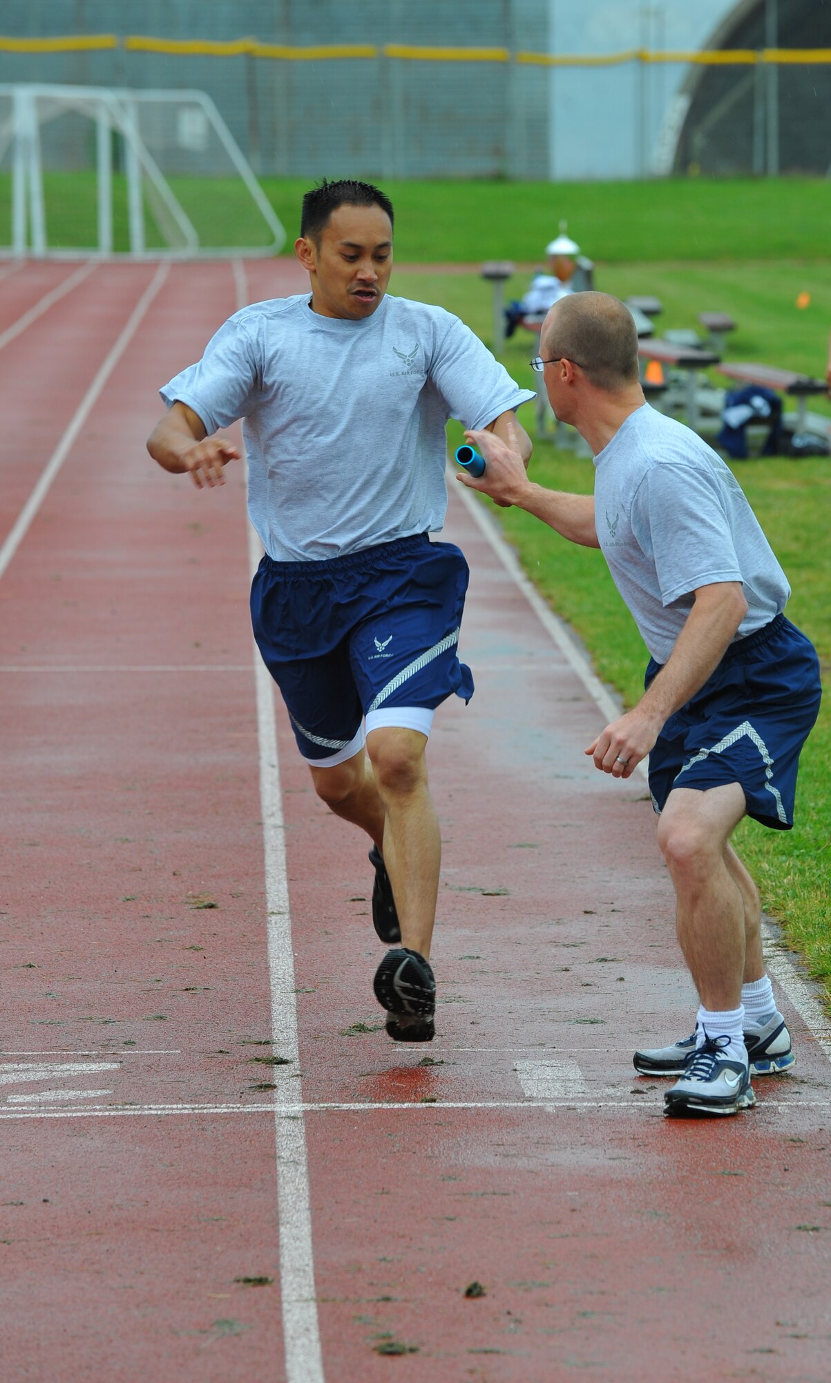SPANGDAHLEM AIR BASE, Germany – Will Villalobos, 52nd Medical Operations Squadron, passes the baton to Christopher Pundsack, 52nd MDOS, during the Iron Flight relay event here July 13. The 52nd EMS ammo team won the Iron Flight competition after a tie-breaker tug-of-war event against the 52nd Force Support Squadron. (U.S Air Force photo/Airman 1st Class Dillon Davis)