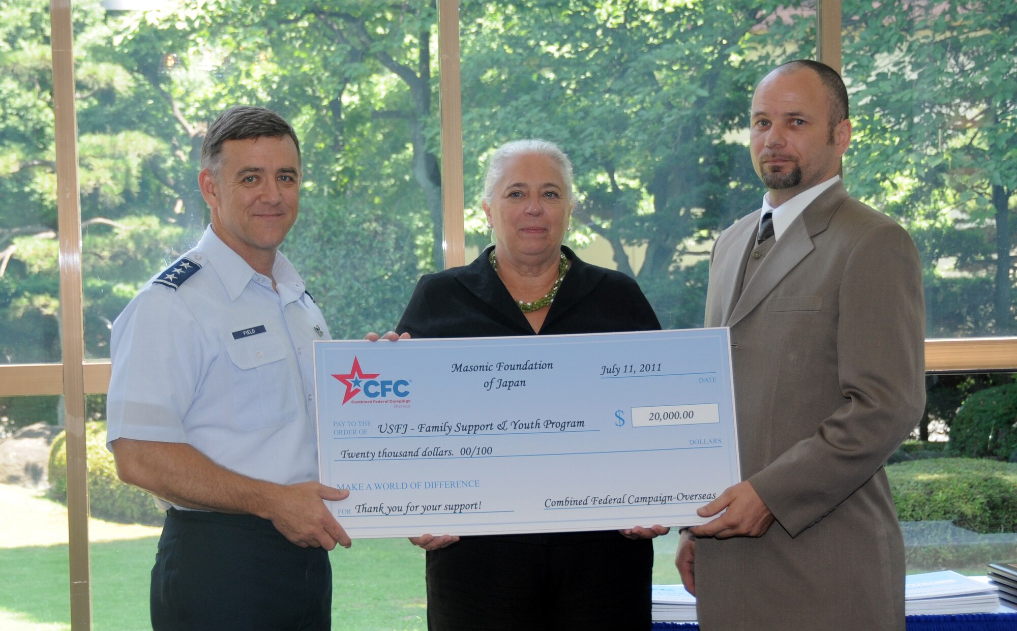 YOKOTA AIR BASE, Japan -- (Left to right) Lt. Gen. Burton Field, U.S. Forces Japan and 5th Air Force commander; Ms. Renee Acosta, president and CEO for Global Impact; and Phil Ambrose, a representative from the Tokyo Masonic Foundation, pose for a photo at the Combined Federal Campaign check presentation and unit awards ceremony at Yokota Air Base, Japan, July 11, 2011. The USFJ donated more than $2.9 million to the CFC, for 2010. (U.S. Air Force photo/Airman 1st Class Krystal M. Garrett)