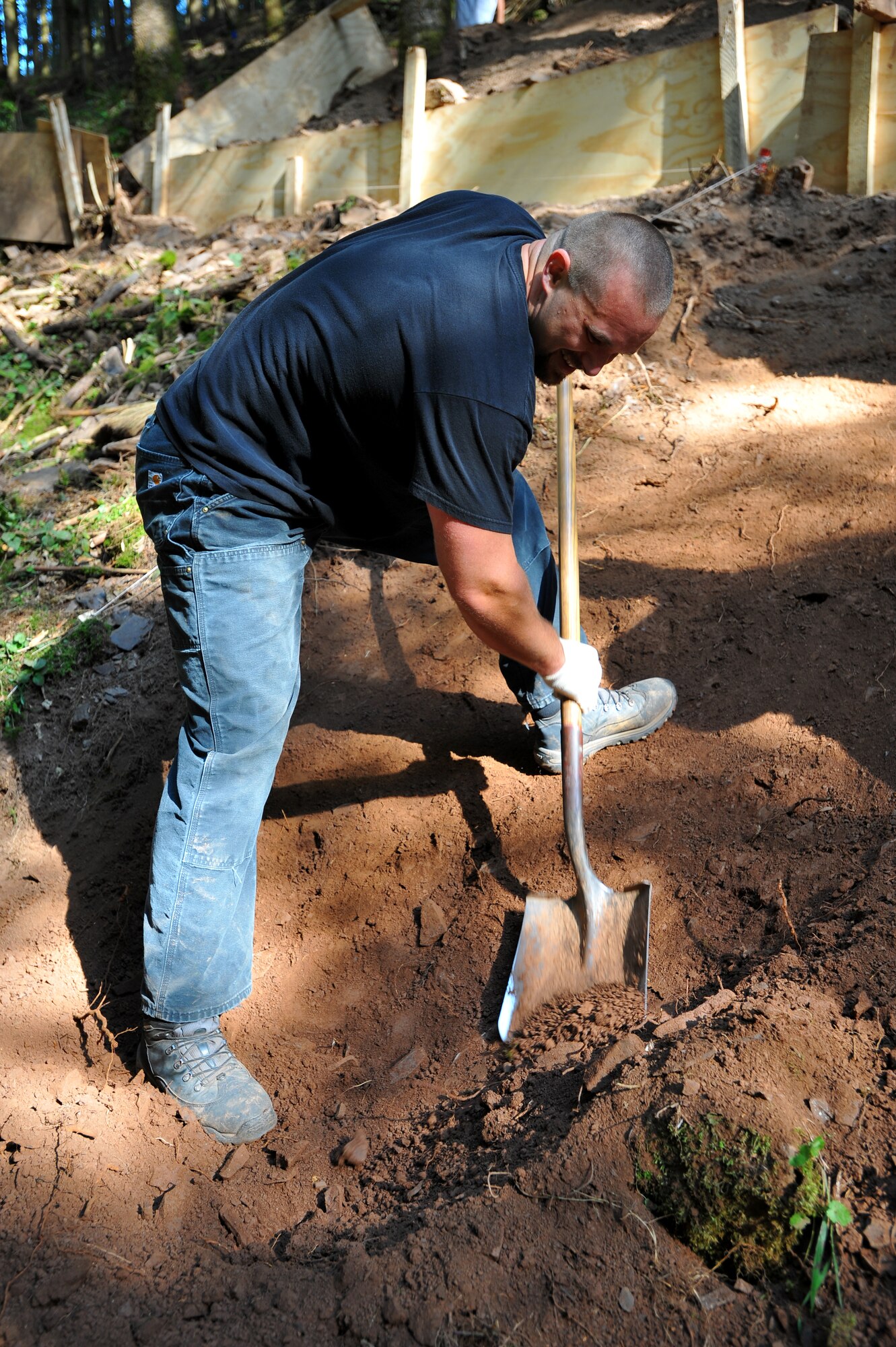 BETTENFELD, Germany – Jason English, Joint Prisoner of War, Missing in Action Accounting Command volunteer, shovels dirt and rock into buckets at an excavation site here July 12. The mission of the JPAC team here is to organize the search and recovery of unaccounted-for American service members from World War II. (U.S. Air Force photo/Airman 1st Class Dillon Davis)