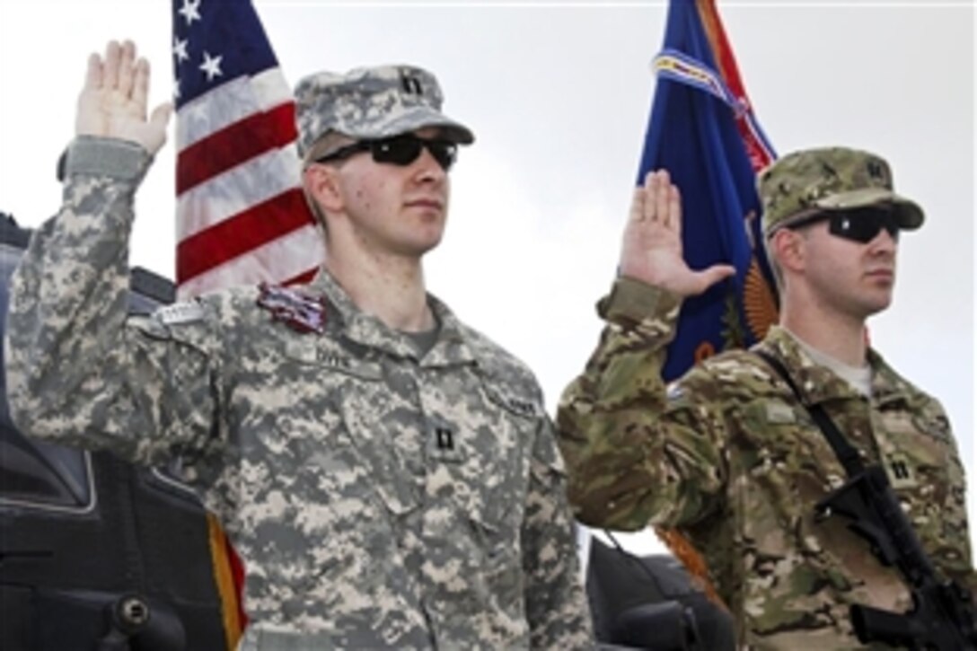 U.S. Army Capts. Nathan Dyer, left, and Jonathan Dyer, identical twins, take the oath of office at Forward Operating Base Salerno, Afghanistan, July 2, 2011. Nathan, an AH-64D Apache pilot and platoon leader assigned the 10th Mountain Division's 1st Combat Aviation Brigade, and Jonathan, the logistics and supply officer for the 40th Engineer Battalion, 170th Infantry Brigade Combat Team,  were both promoted to captain before taking the oath.