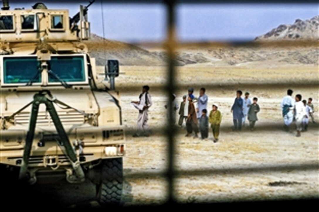 Afghan children approach a U.S Forces convoy to ask for spent brass, pens and water in the Alingar district of Laghman province, Afghanistan, July 13, 2011. The convoy includes members of the Laghman Provincial Reconstruction team, en route to check on a school construction site and talk with Alingar leaders.