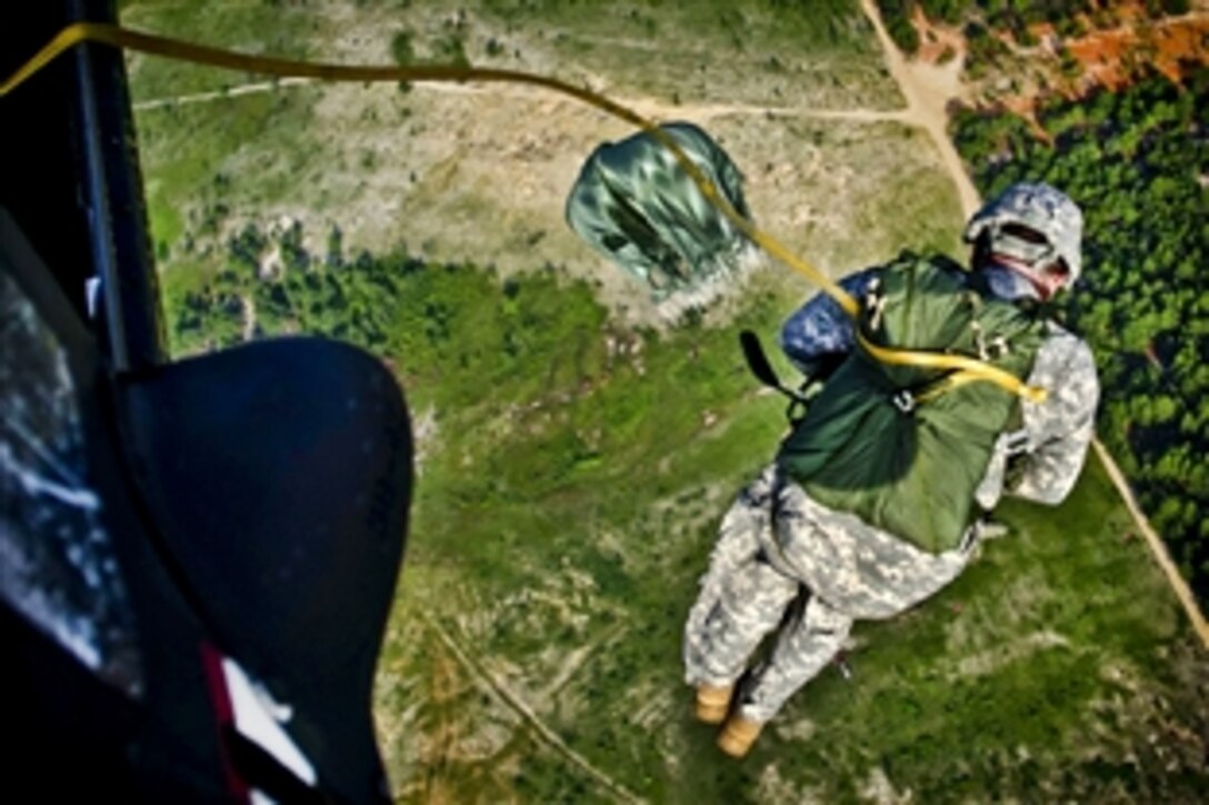 Army Chief Warrant Officer Five Tom Travis exits from a UH-60 Black Hawk helicopter over St. Mere Eglise at Fort Bragg, N.C., July 13, 2011. Travis jumped with U.S. Army Civil Affairs Operations Command, Airborne troops, who hosted the U.K.'s 4th Parachute Regiment in a joint training mission.