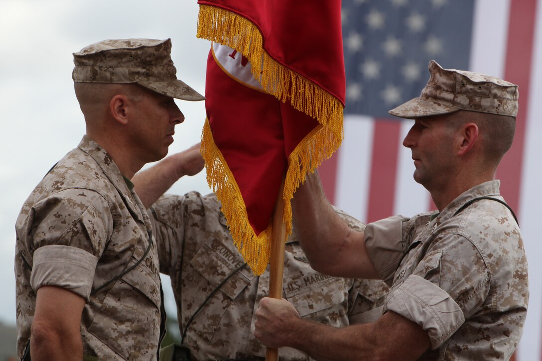 Col. Thomas B. Eipp (right), from Sonoma, Calif., presents the colors of Combat Logistics Regiment 1, 1st Marine Logistics Group, to Col. James C. Caley, from Kingston, Wash., on Camp Pendleton, Calif., July 15.