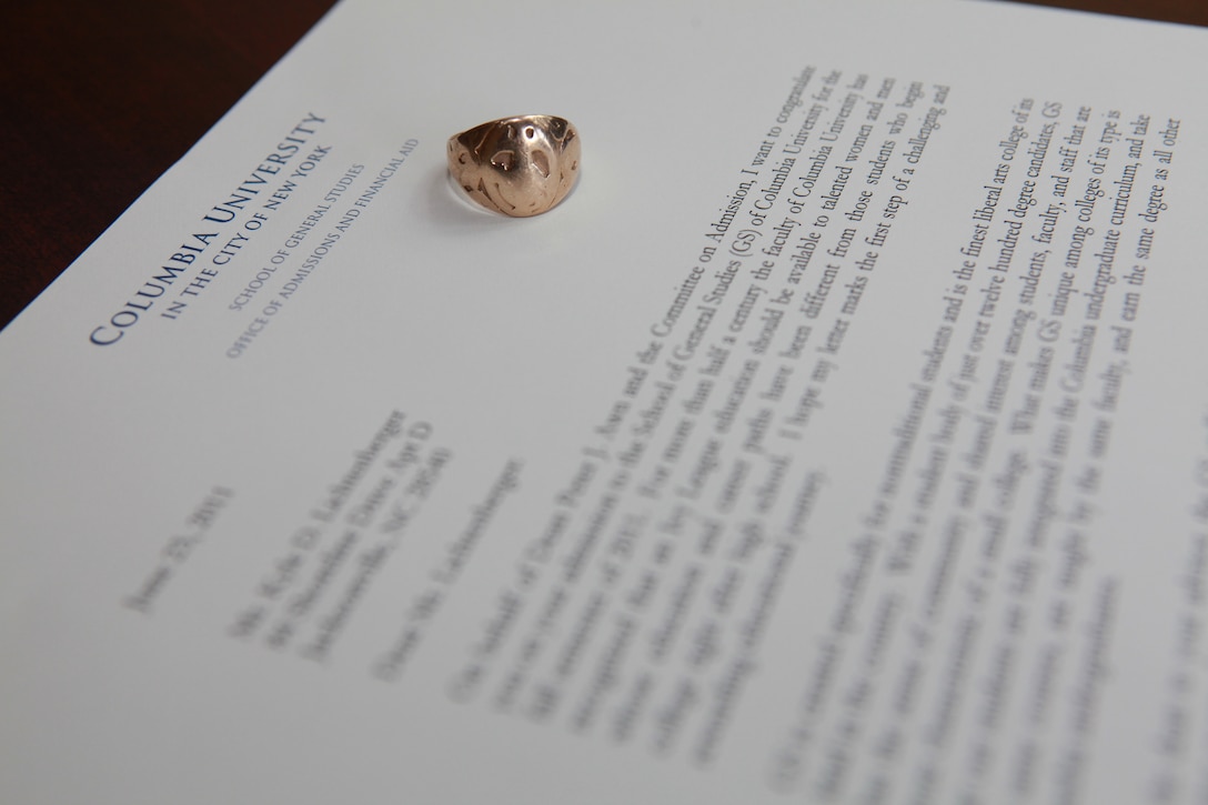 A solid gold ring baring the Marine Corps emblem, which was purchased by Cpl. Kyle Lichtenberger’s great-grandfather in 1918, rests on top of his acceptance letter from Columbia University in New York, at his home in Jacksonville, N.C. July 15. Kyle is the fourth generation of his family to serve in the Marine Corps. He received the ring on his wedding day January 26, 2008. (Official U.S. Marine Corps Photo Illustration by Sgt. Richard Blumenstein)