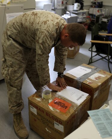 Petty Officer 2nd Class Joshua D. Croxton, the blood coordinator for the 2nd Marine Logistics Group (Forward), prepares a box of blood to be shipped to a forward operating base at the Role III hospital on Camp Bastion, Afghanistan, July 16, 2011.  Croxton, a Niceville, Fla., native, restructured the way blood is distributed throughout Helmand province, Afghanistan, which resulted in approximately a 30 percent decrease of wasted blood.