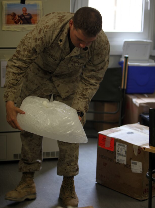 Petty Officer 2nd Class Joshua D. Croxton, the blood coordinator for the 2nd Marine Logistics Group (Forward), breaks up ice so he can prepare a box of blood to be shipped to a forward operating base at the Role III hospital on Camp Bastion, Afghanistan, July 16, 2011. Croxton, a Niceville, Fla., native, restructured the way blood is distributed throughout Helmand province, Afghanistan, which resulted in approximately a 30 percent decrease of wasted blood.