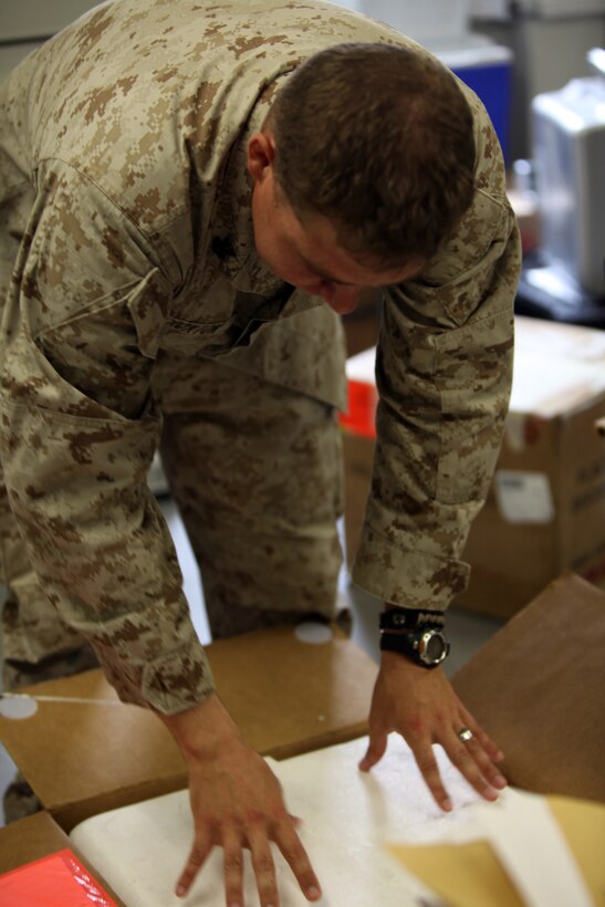 Petty Officer 2nd Class Joshua D. Croxton, the blood coordinator for the 2nd Marine Logistics Group (Forward), prepares a box of blood to be shipped to a forward operating base at the Role III hospital on Camp Bastion, Afghanistan, July 16, 2011.  Croxton, a Niceville, Fla., native, restructured the way blood is distributed throughout Helmand province, Afghanistan, which resulted in approximately a 30 percent decrease of wasted blood.