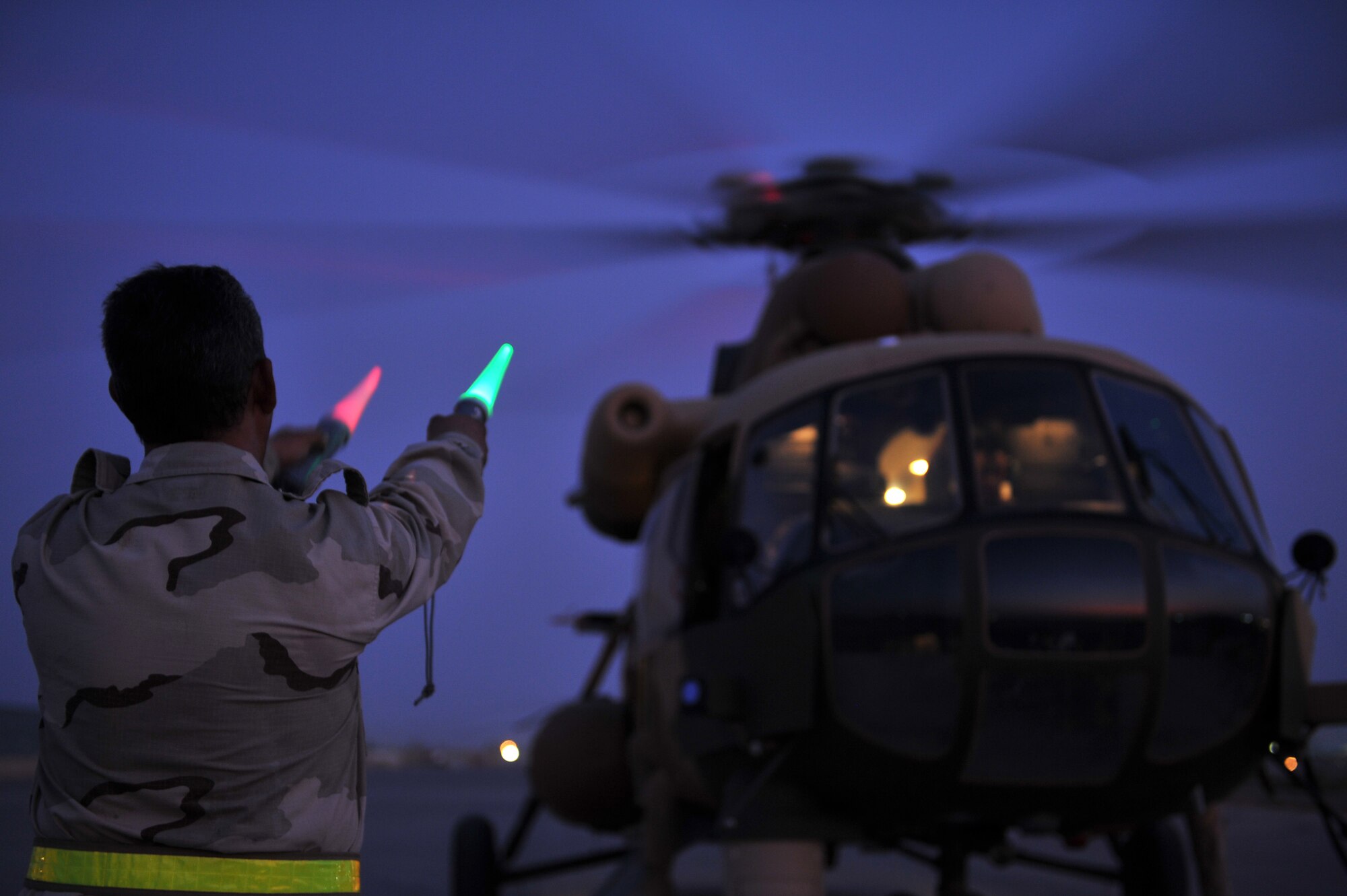 An Iraqi Army Aviation Command, Squadron 15 ground crew member marshals a Mi-171 helicopter prior to takeoff at Taji Air Base, Iraq, July 11, 2011. Assigned at Taji Air Base, the 721st Air Expeditionary Advisory Squadron trains, advises and assists Iraqi pilots and maintenance personnel, focusing on sustainability, reliability and interoperability. (U.S. Air Force photo/Tech. Sgt. Josef E. Cole III)



