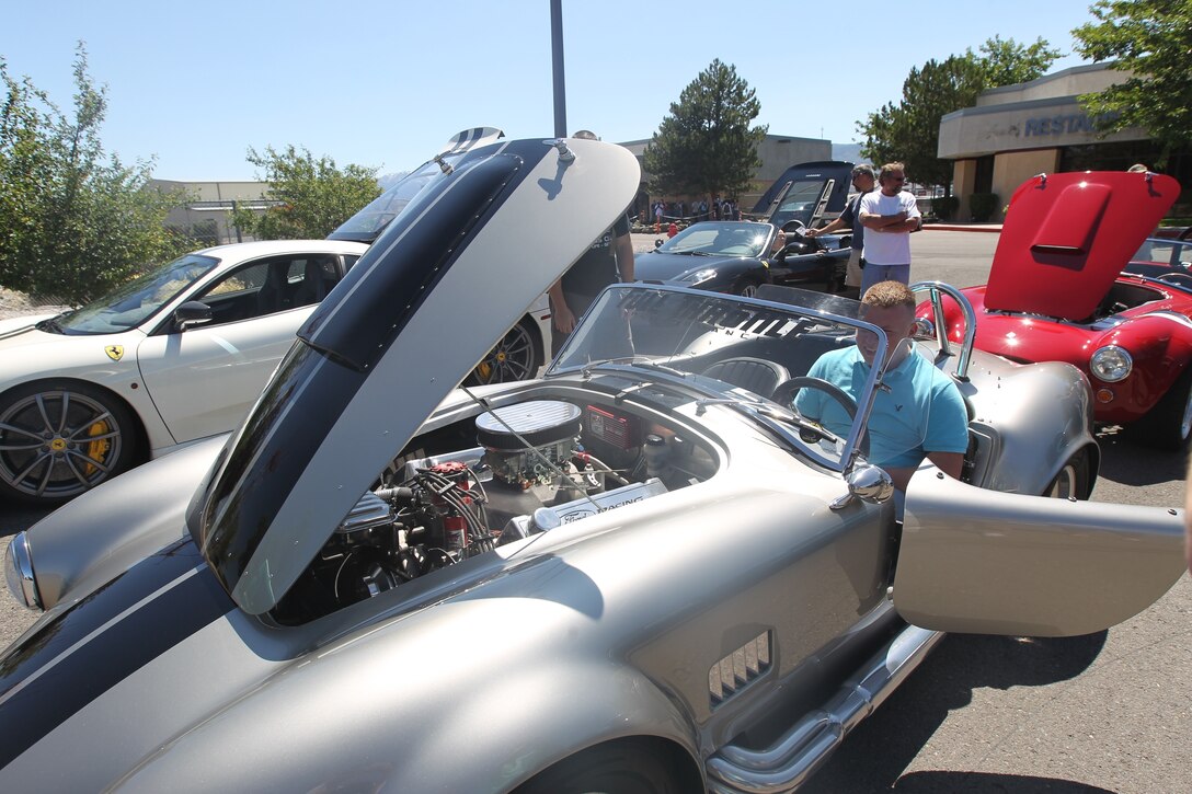 Lance Cpl. Matthew Pfeil, a network operator with Communications Company, Headquarters and Service Battalion, 4th Marine Logistics Group, sits in the driver seat of a hot rod brought in for the service members to view by local business owners at the Reno-Tahoe International Airport July 17.