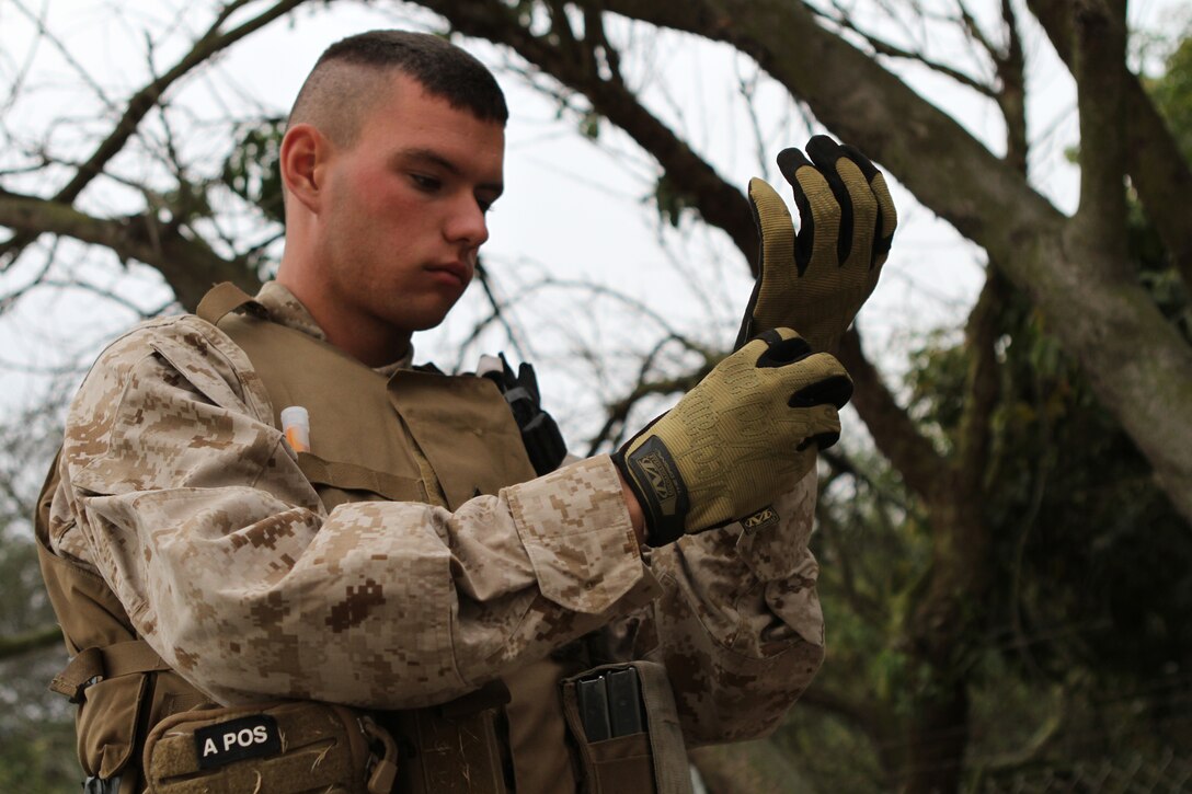 A Marine with MWCS-18, Marine Air Control Group 18, inspects the contents of a jungle survival kit at the Jungle Warfare Training Center July 18. The compact survival kit is meant to be carried on a person at all times in case of a survival situation.