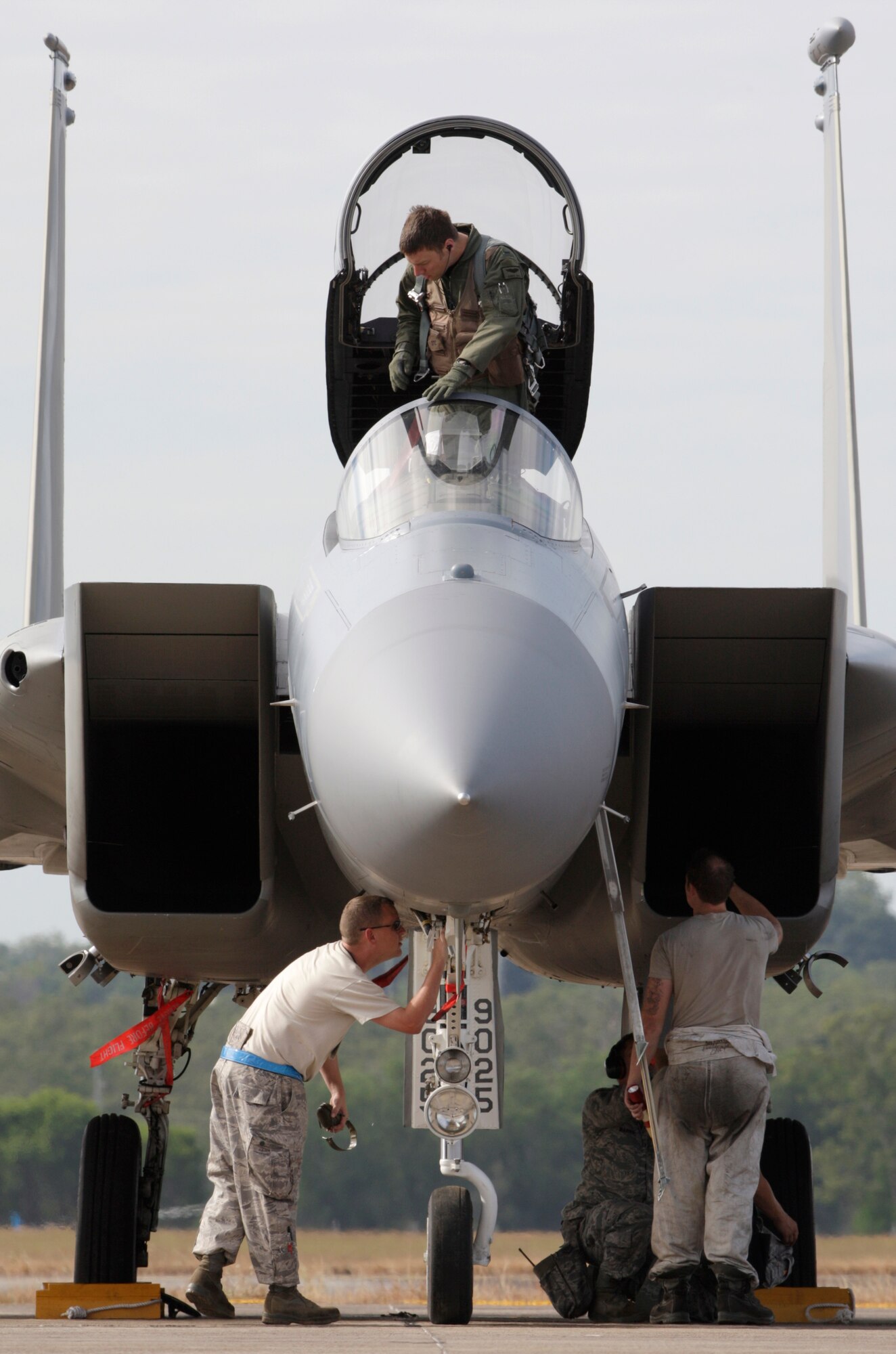 A pilot from the United States Air Force's 44th Fighter Squadron based exits from an F-15C Eagle while ground crew from the 18th Maintenance Squadron preform after flight checks after an afternoon familiarisation sortie as part of the lead up to Exercise Talisman Sabre 2011 at  RAAF Base Darwin. Mid Caption: RAAF Base Darwin is hosting six F-15C Eagle fighter jets from the United States Air Force?s 44th Fighter Squadron for Exercise Talisman Sabre 2011. The Eagles, based at Kadena Air Base in Okinawa, Japan, are being supported by technicians from the 18th Maintenance Squadron, also from Kadena. These aircraft are conducting missions over training areas in the Northern Territory with a mix of United States Air Force, Navy, and Royal Australian Air Force aircraft.