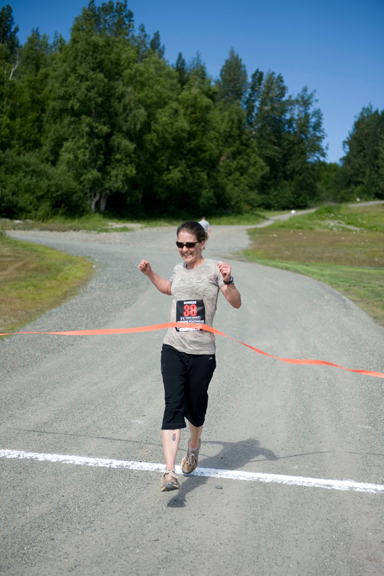 JOINT BASE ELMENDORF-RICHARDSON, Alaska - Maj. Kimberly Riggs, with the 176th Civil Engineer Squadron, crosses the finish line of the 176th Wing's Duathlon , July 16, 2001. The duathlon was created to help encourage a culture of fitness and esprit de corps within the wing and was sponsored by the Kulis Senior Enlisted Association. The event kicked off the "Kulis Family" Block Picnic, an annual wing get-together with co-workers and family. The course was roughly a 1.5 mile run, five mile bike ride and then a mile run to finish. Alaska Air National Guard photo by Master Sgt. Shannon Oleson