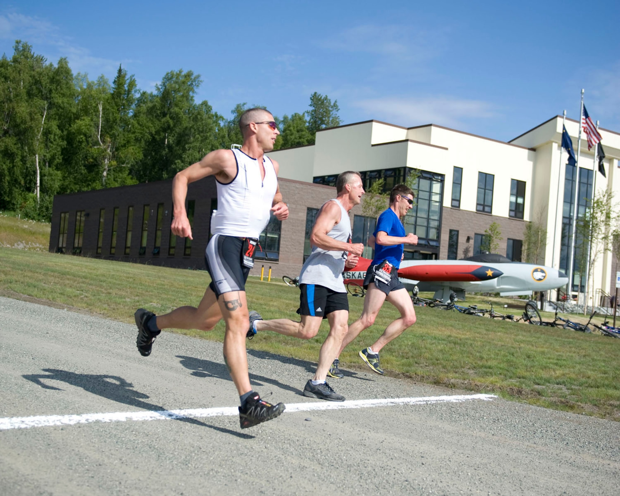 JOINT BASE ELMENDORF-RICHARDSON, Alaska - Air Guardsmen Capt. Shane Garling, MSgt Jon Gibson and Capt. James Zwiefel complete the first leg of a duathlon during drill, July 16, 2001. The duathlon was created to help encourage a culture of fitness and esprit de corps within the wing and was sponsored by the Kulis Senior Enlisted Association. The event kicked off the "Kulis Family" Block Picnic, an annual wing get-together with co-workers and family. The course was roughly a 1.5 mile run, five mile bike ride and then a mile run to finish. Alaska Air National Guard photo by Master Sgt. Shannon Oleson