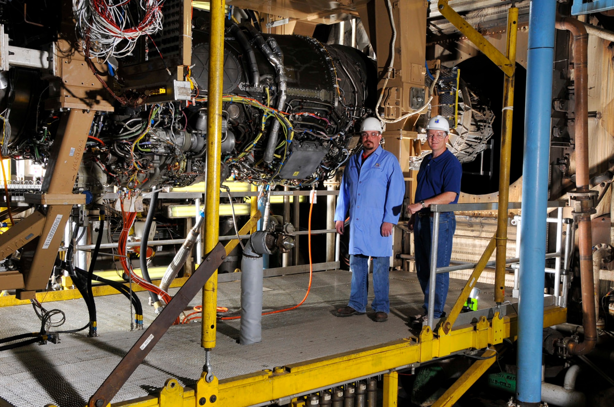 From left, Greg Crabtree, ATA outside machinist, and Jeff Dodd, ATA project manager on the test, stand in front of an F135 engine undergoing validation and altitude development testing in AEDC’s altitude test cell C-1. The F135 engine is a Conventional Take Off and Landing and Carrier Variant (CTOL/CV) that has been designated for low rate initial production to the U.S. government for the F-35 Lightning II program. The engine has been modified and improved based on findings from the F-35 flight and ground test program. (Photo by Rick Goodfriend) 