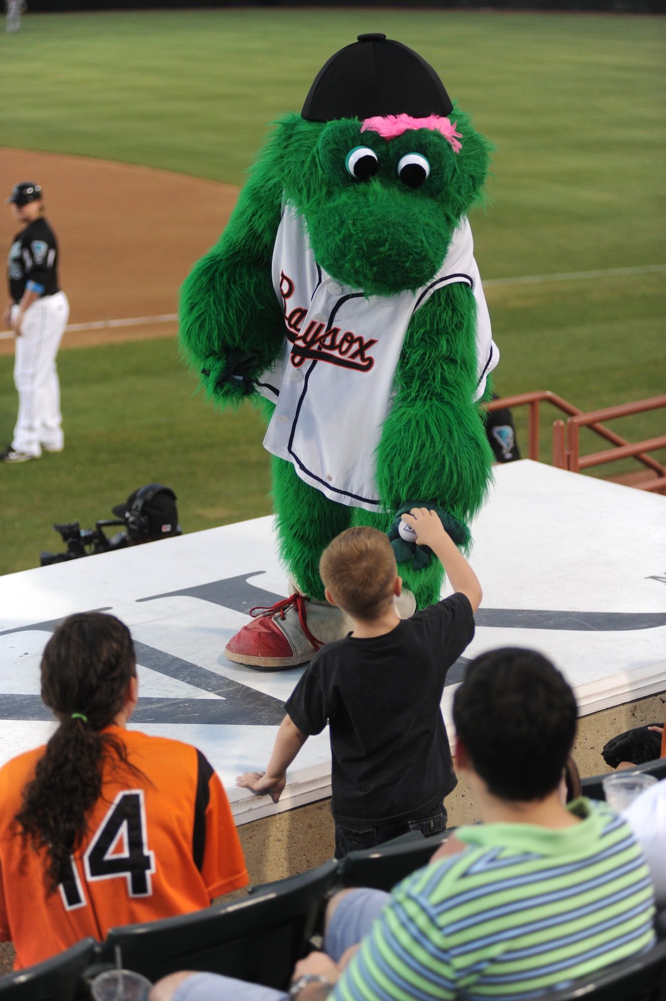 Louis, the Bowie Baysox mascot, signs a baseball for a young fan at Andrews Night July 15.  The Baysox are the AA team for the Baltimore Orioles. (U.S. Air Force Photo by Senior Airman Torey Griffith)
