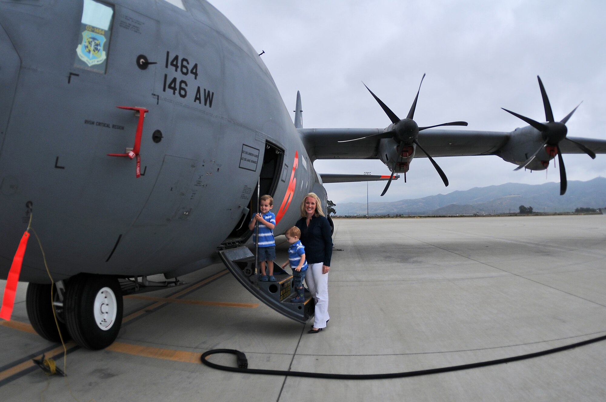 Megan Glynn, named the 2011 Air Force Spouse of the Year in an award program sponsored by Military Spouse magazine, stands by the steps of a C-130J Super Hercules July 13, 2011, with JP and Murphy.  Her husband, Maj. Matt Glynn, is a C-130J pilot with the California Air National Guard’s 146 Airlift Wing at Channel Islands ANG Station near Oxnard, Calif.  (U.S. Air Force photo)