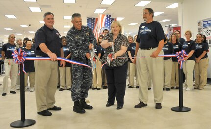 Jeff Wilder, Cdr. Charles Phillip, Angela Mauras and Joseph Puryer (left to right) cut the tape during a ribbon cutting ceremony July 12 at Joint Base Charleston - Air Base marking the completion of the 18-month renovation of the Exchange. Wilder is the Exchange Food Court manager, Phillip is the 628th Mission Support Group executive officer, Mauras is the Exchange general manager and Puryer is the Exchange project manager.  (U.S. Air Force photo/ Airman 1st Class Jared Trimarchi)
