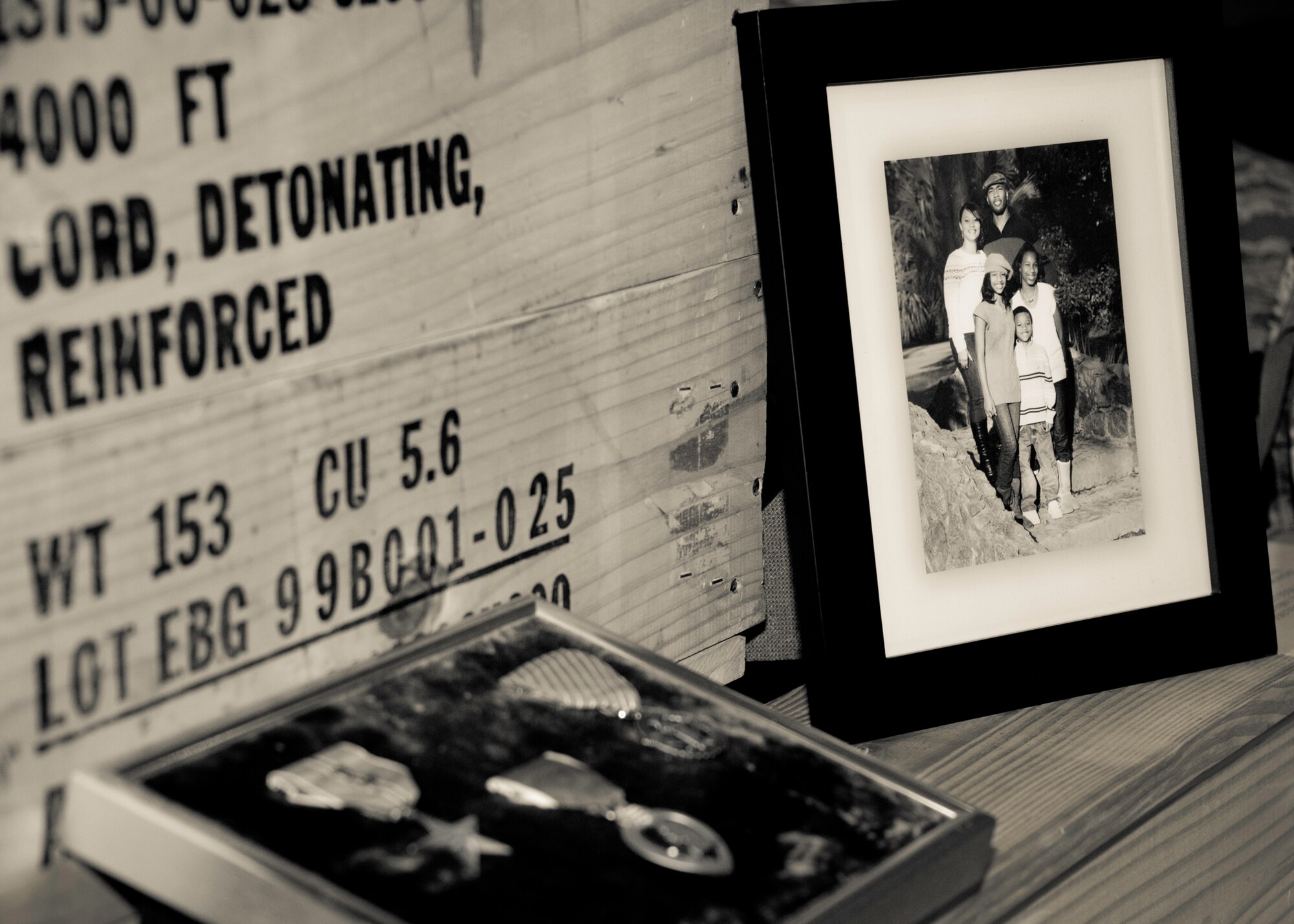 A photo of Tech. Sgt. Daniel Douville and his family sits beside his medals as part of a memorial display honoring the explosive ordnance disposal technician at a ceremony at Eglin Air Force Base, July 14.  Douville died June 26, as a result of injuries suffered from an improvised explosive device in Afghanistan.  Friends, family and the local community turned out to remember and praise his contributions to his country.  (U.S. Air Force photo/Samuel King Jr.)