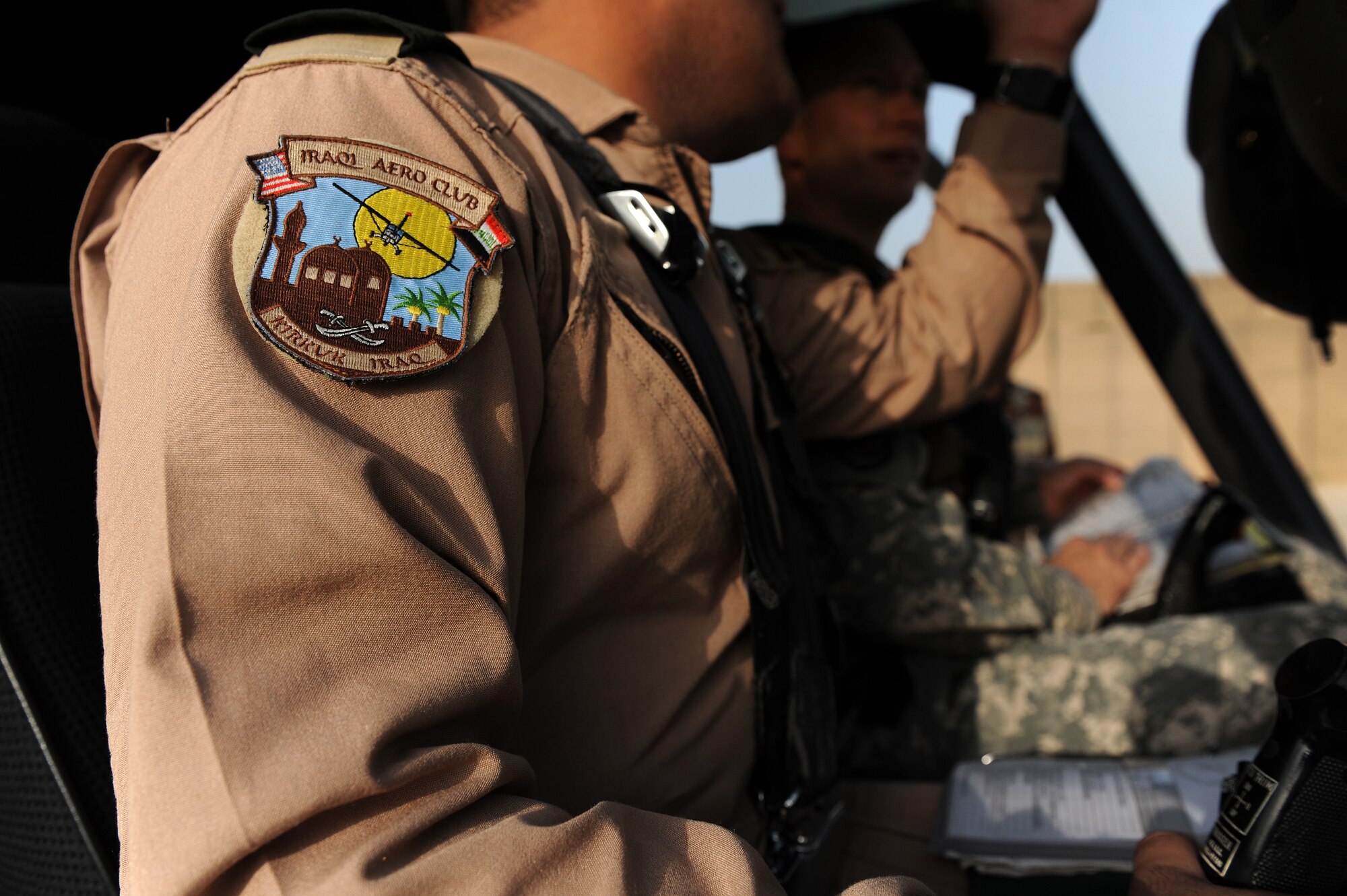 U.S. Army Maj. Kevin Ferner (background), 721st Air Expeditionary Advisory Squadron, and Bell 407 helicopter instructor pilot assists a pilot of the Iraqi Army Aviation Command, Squadron 21 in completing a pre-flight checklist prior to a training flight, at Taji Air Base, Iraq, July 12, 2011. The 721st AEAS trains, advises and assists Iraqi pilots and maintenance personnel, focusing on sustainability, reliability and interoperability. (U.S. Air Force photo/Staff Sgt. Mike Meares)




