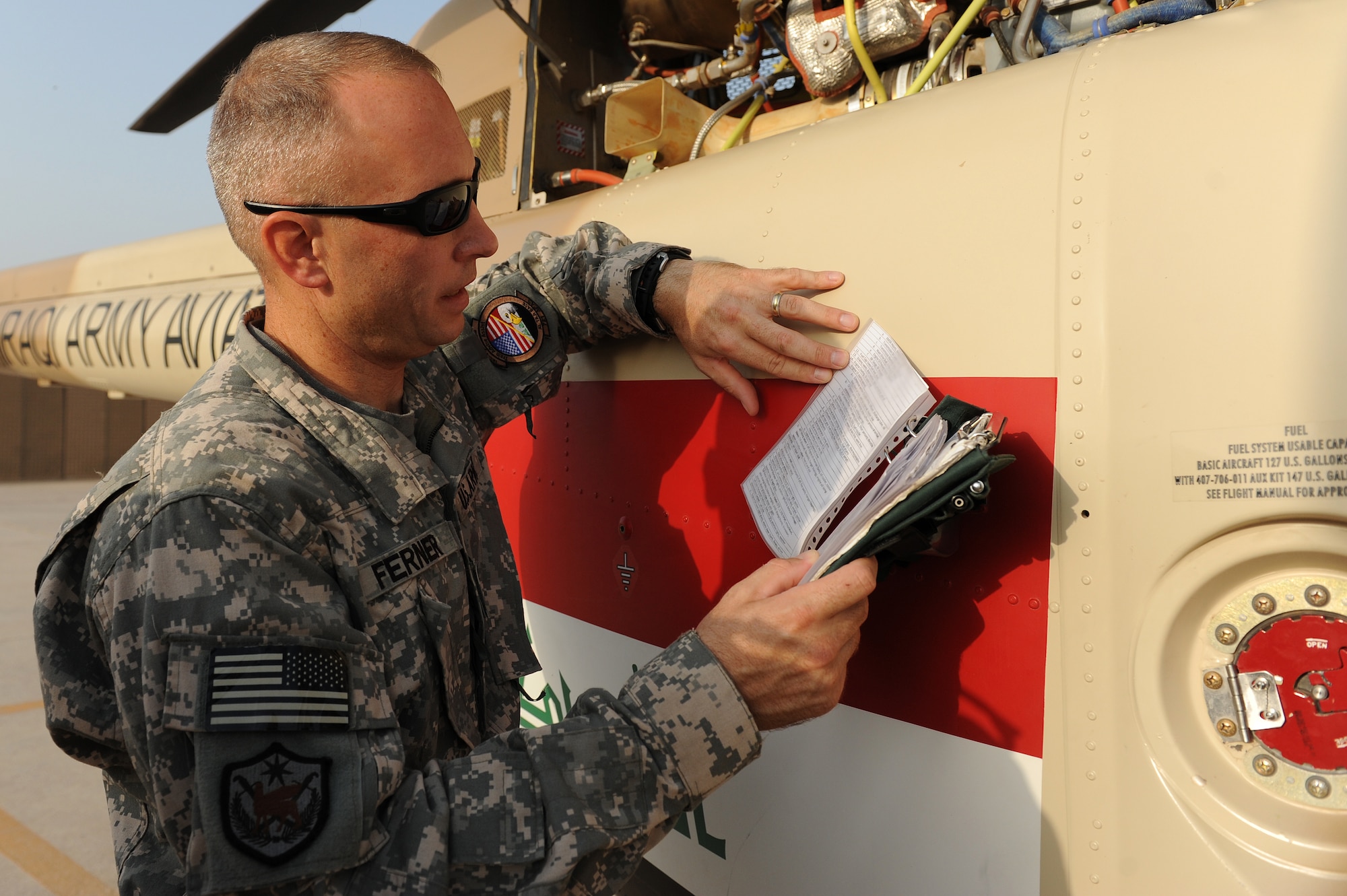 U.S. Army Maj. Kevin Ferner, 721st Air Expeditionary Advisory Squadron and Bell 407 helicopter instructor pilot folloews a pre-flight checklist prior to a training flight, at Taji Air Base, Iraq, July 12, 2011. The 721st AEAS trains, advises and assists Iraqi pilots and maintenance personnel, focusing on sustainability, reliability and interoperability. (U.S. Air Force photo/Staff Sgt. Mike Meares)



