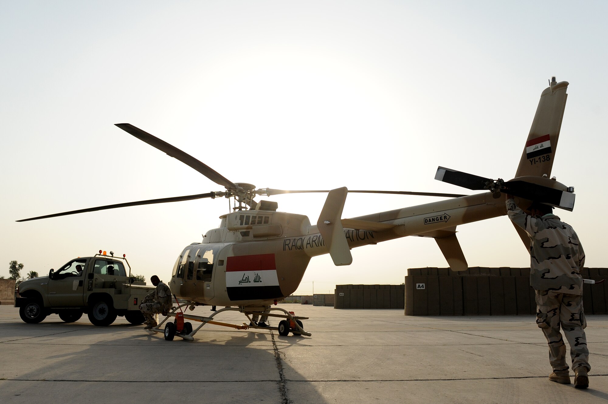 An Iraqi Army Aviation Command, Squadron 21 ground crew member guides a Bell 407 helicopter to it's hangar at Taji Air Base, Iraq, July 14, 2011. Assigned at Taji Air Base, the 721st Air Expeditionary Advisory Squadron trains, advises and assists Iraqi pilots and maintenance personnel, focusing on sustainability, reliability, and interoperability. (U.S. Air Force photo/Staff Sgt. Mike Meares)







