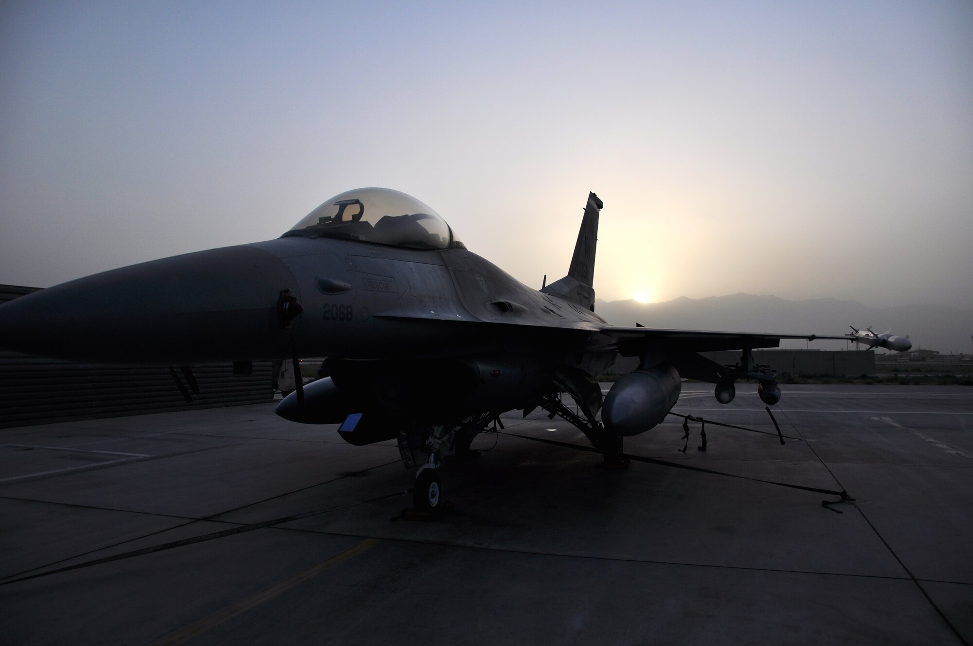 BAGRAM AIRFIELD, Afghanistan – The sun begins to set behind Afghan mountains, casting a shadow over an F-16 Fighting Falcon from the 555th Expeditionary Fighter Squadron July 15. (U.S. Air Force photo/Capt. Korry Leverett)