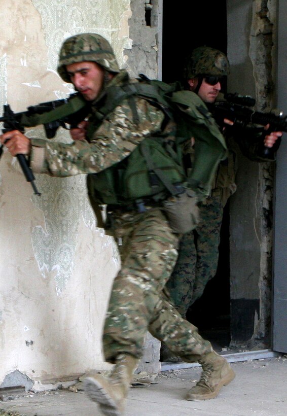 Sgt. Spencer McAvoy, a squad leader with Company A, Anti-Terrorism Battalion, clears a room with Georgian soldiers here July 19 during Exercise Agile Spirit 2011.  Agile Spirit is designed to increase interoperability between the forces by exchanging and enhancing each other’s capacity in counterinsurgency and peacekeeping operations, including: small unit tactics, convoy operations, and counter-Improvised Explosive Device training.::r::::n::