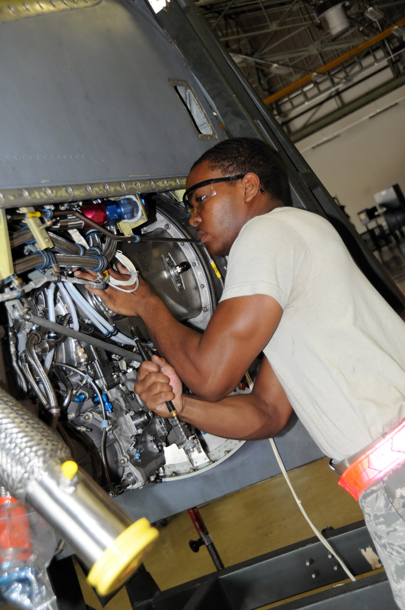 YOKOTA AIR BASE, Japan -- Airman 1st Class Jon Jarvis, 374th Maintenance Squadron Propulsion Flight aerospace propulsion apprentice, attaches a cannon plug to the left hand distribution harness of a T56-15 engine at Yokota Air Base, Japan, July 14, 2011. Airman Jarvis performs maintenance on C-130 Hercules engines, helping make sure they are safe for use. (U.S. Air Force photo/Airman 1st Class Krystal M. Garrett)