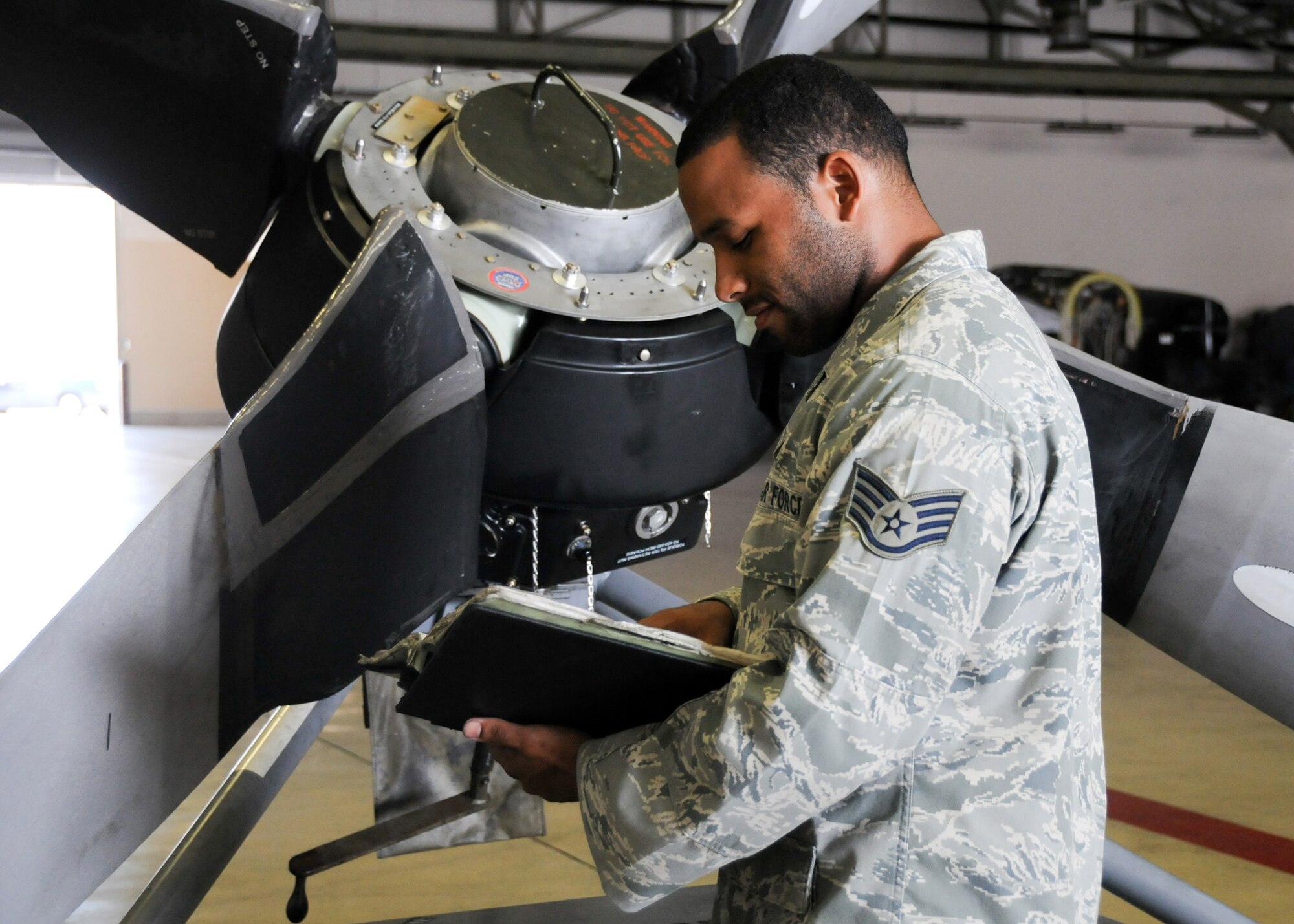 YOKOTA AIR BASE, Japan -- Staff Sgt. Anthony Benitez, 374th Maintenance Squadron Propulsion Flight aerospace propulsion journeyman, checks a technical order while conducting a five-level inspection of a propeller assembly at Yokota Air Base, Japan, July 14, 2011. Maintainers use technical orders, manuals showing step-by-step instructions on maintenance tasks, to double-check their work and use the safest and most efficient means to complete their mission. (U.S. Air Force photo/Airman 1st Class Krystal M. Garrett)

