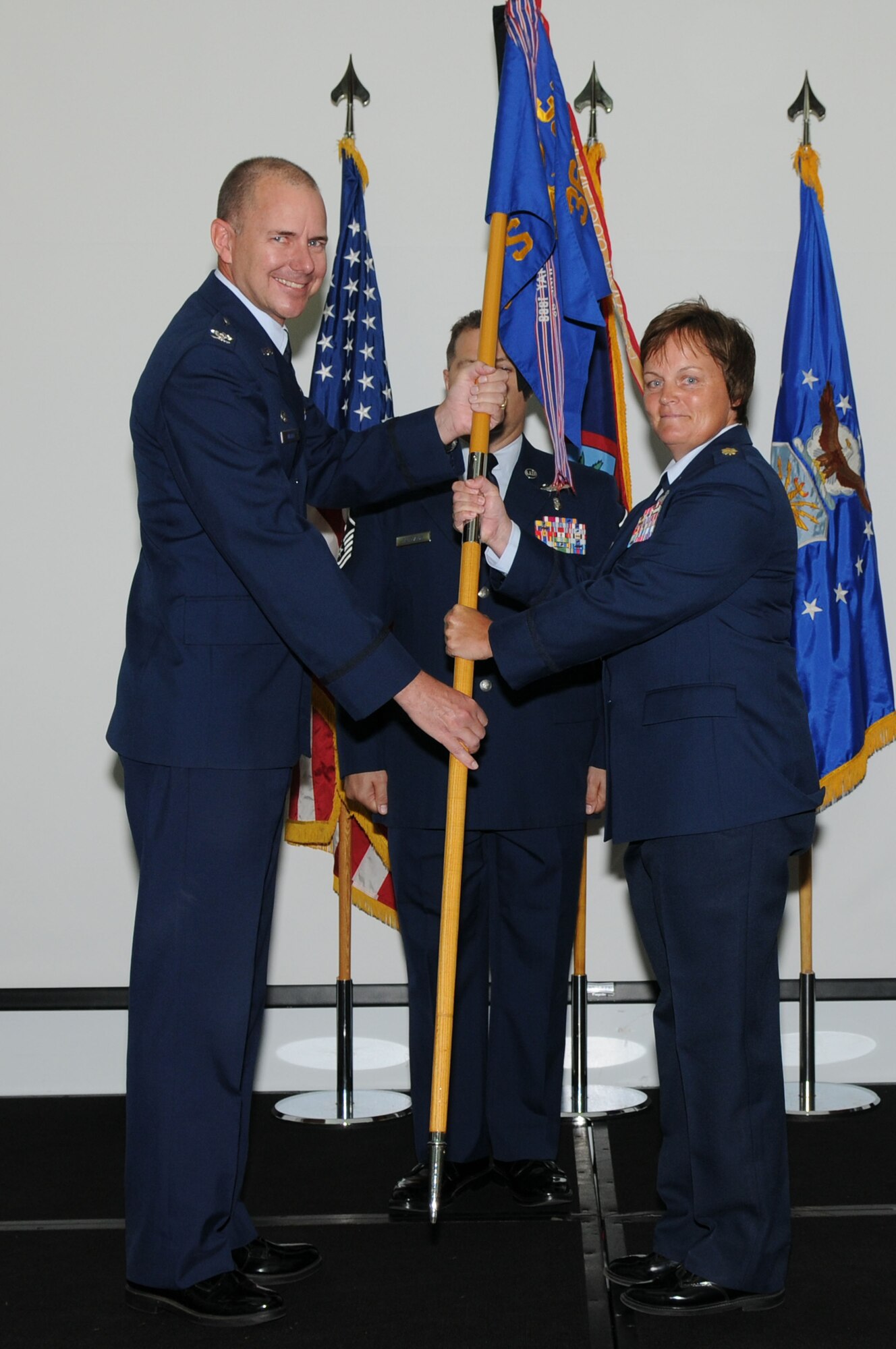 Col. Alan Wieder, former 36th Mission Support Group commander, passes the 36th Security Forces Squadron  guidon to Maj. Kathy Jordan, newly appointed 36 SFS commander, during a change of command ceremony here, July 14.(U.S. Air Force photo/Senior Airman Carlin Leslie)
