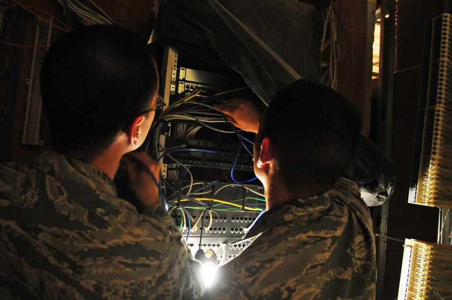 Senior Airman James Owen and Senior Airman Lucas Payne, 2nd Communications Squadron, patch a switch and activate a port on Barksdale Air Force Base, La., July 19. Due to port security, which prevents different computers to be switched between different internet ports, the Airmen of the Communications Focal Point are routinely called out to re-activate ports after office relocations or personnel changes. (U.S Air Force photo/Senior Airman Joanna M. Kresge)