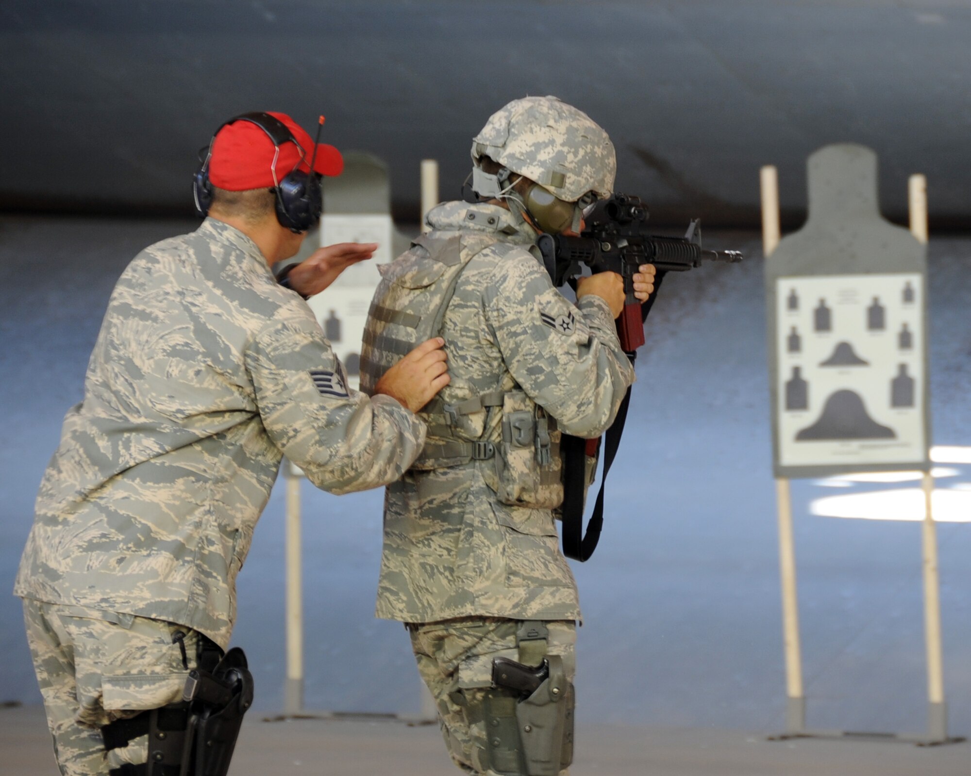 ALTUS AIR FORCE BASE, Okla. -- Staff Sgt. Matthew Treadwell, 97th Security Forces Squadron NCO in charge of Combat Arms, guides an airman from the 97th SFS Rodeo team during a team practice at the Combat Arms shooting range July 19, 2011in preparation for the 2011 Air Mobility Command Rodeo. The AMC Rodeo is a biennial competition hosted by the AMC and will take place at Joint Base Lewis-McChord, Wash. July 24-29. The international competition focuses on improving worldwide air mobility forces' professional core abilities. (U.S. Air Force photo by Airman 1st Class Kenneth W. Norman / Released / 97th Air Mobility Wing Public Affairs)