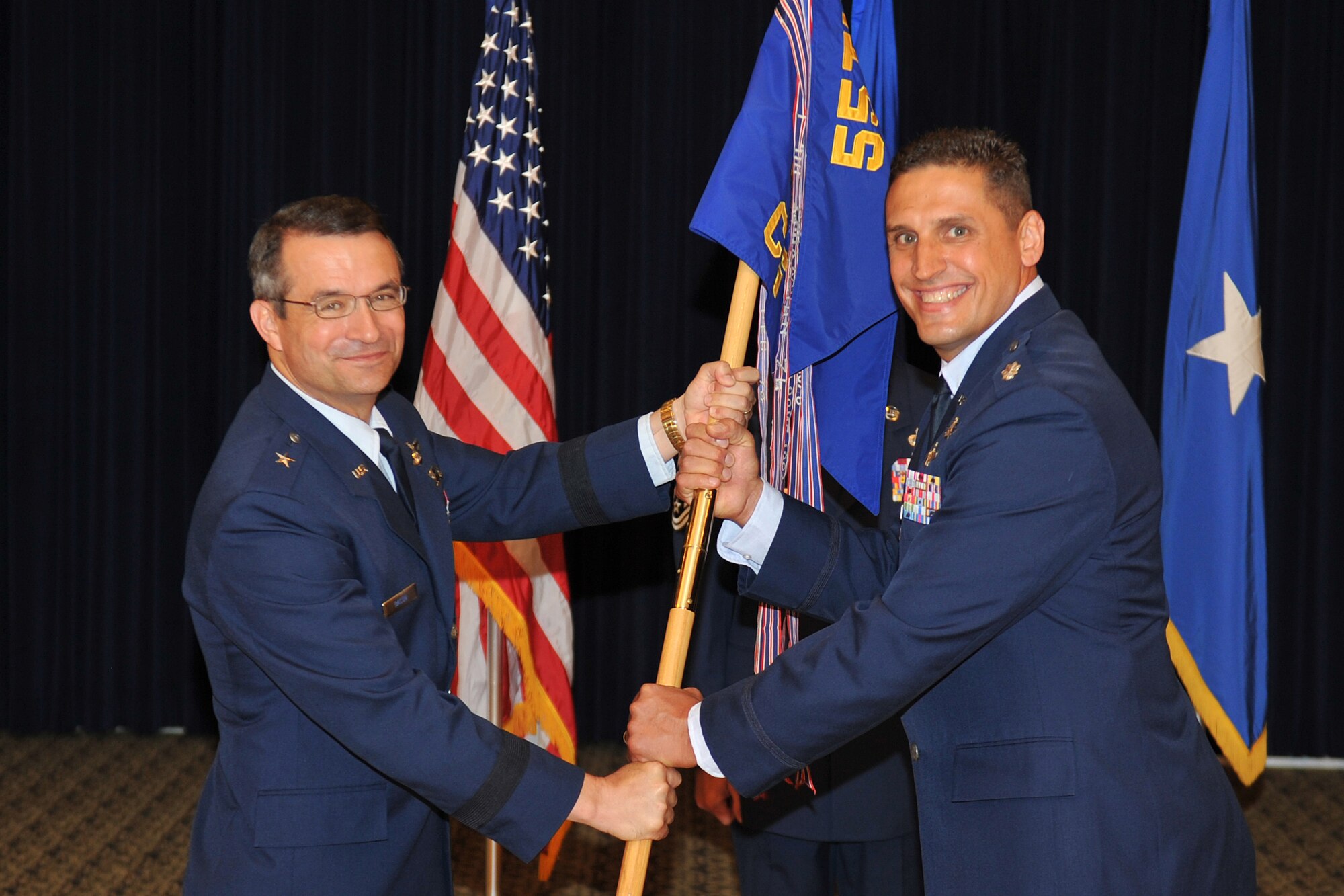 Air Force Lt. Col. Donovan L. Routsis, (right), assumes command of the 55th Communications Group during a change of command ceremony held in the Patriot Club on Offutt Air Force Base, Neb., July 19. Brig. Gen. Donald J. Bacon, 55th Wing commander, presided over the ceremony that welcomed Routsis to the 55th CG. (U.S. Air Force Photo by Jeff W. Gates/Released)
