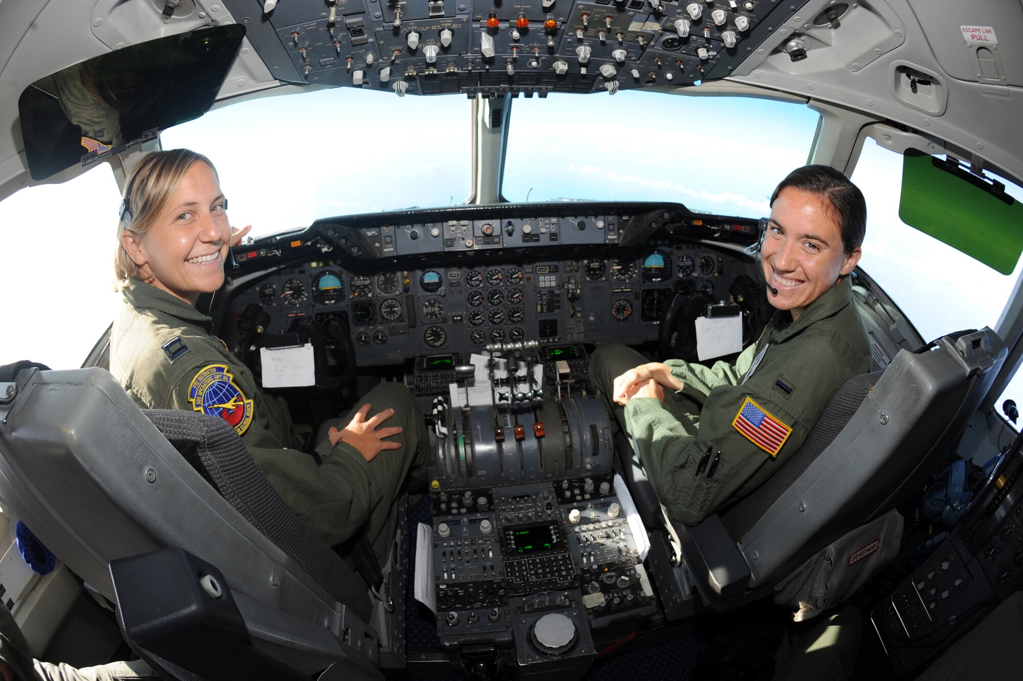 Military Team USA soccer players Capt. Wendy Emminger and 1st Lt. Mandi Messinger of Joint Base McGuire-Dix-Lakehurst, N.J., sneak a peek before preparing to land in Rio de Janeiro July 13, 2011.  The two KC-10 Extender pilots were flying their teammates and track and field athletes to Brazil to compete in the 5th CISM Military World Games. (U.S. Army photo/Tim Hipps)