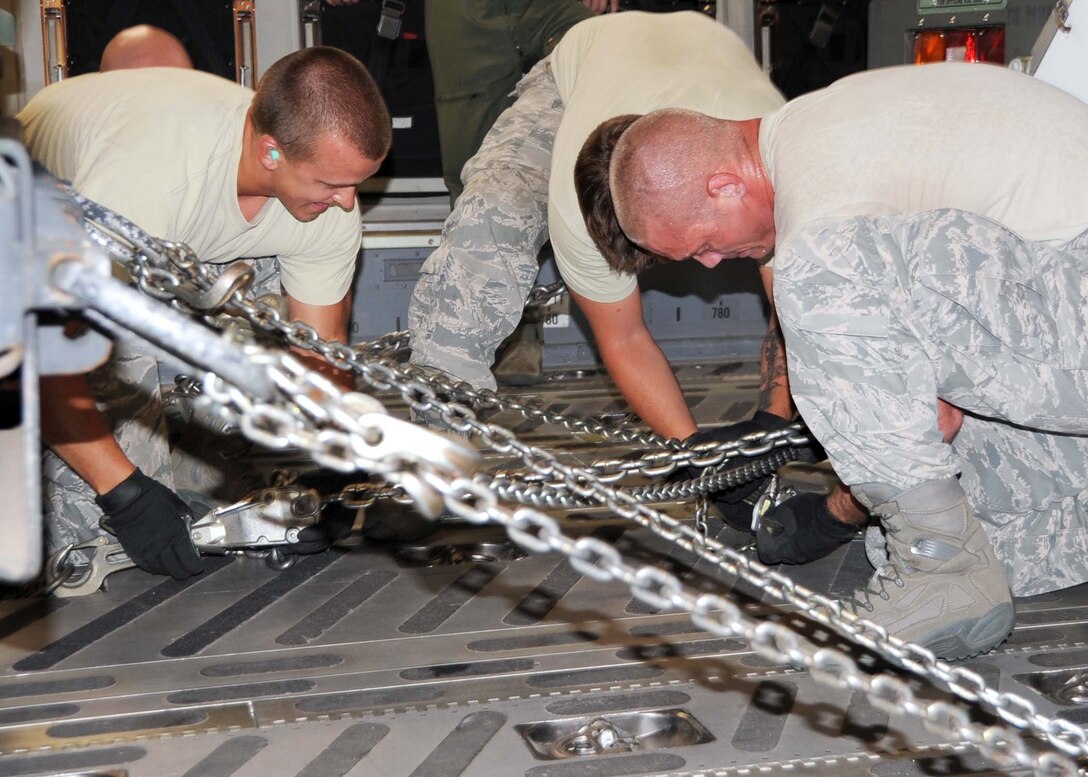 ALTUS AIR FORCE BASE, Okla. –Airman 1st Class Joshua Verran, Senior Airmen Eric Hazelwood and William Martineau, 97th Logistics Readiness Squadron air transportation specialists, chain a Humvee to the cargo deck of a C-17 Globemaster III during a LRS Rodeo upload practice July 18, 2011. The LRS Rodeo team practiced uploading and offloading vehicles in preparation for the Air Mobility Command Rodeo held at Joint Base Lewis-McChord, Wash. July 24-29. (U.S. Air Force photo by Airman 1st Class Christopher Toon/97th Air Mobility-Public Affairs)