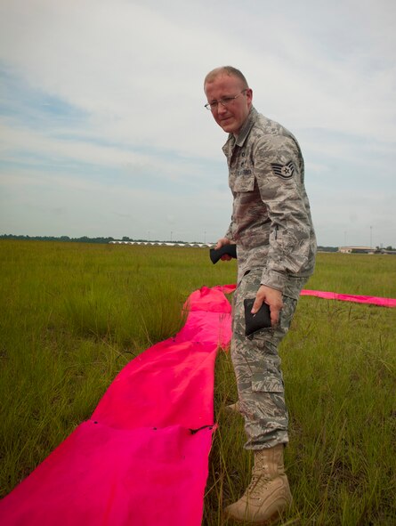 U.S. Air Force Staff Sgt. Clifford Sisk, 38th Rescue Squadron aircrew flight equipment NCO, lays beanbags on a landing mark before a free fall jump at Moody Air Force Base, Ga., July 12, 2011. Sergeant Sisk coordinated the jump and set up the landing site for Master Sgt. Robert Disney, 347th Rescue Group standards and evaluations superintendent, as part of a training mission. (U.S. Air Force photo by Airman 1st Class Joshua Green/Released)
