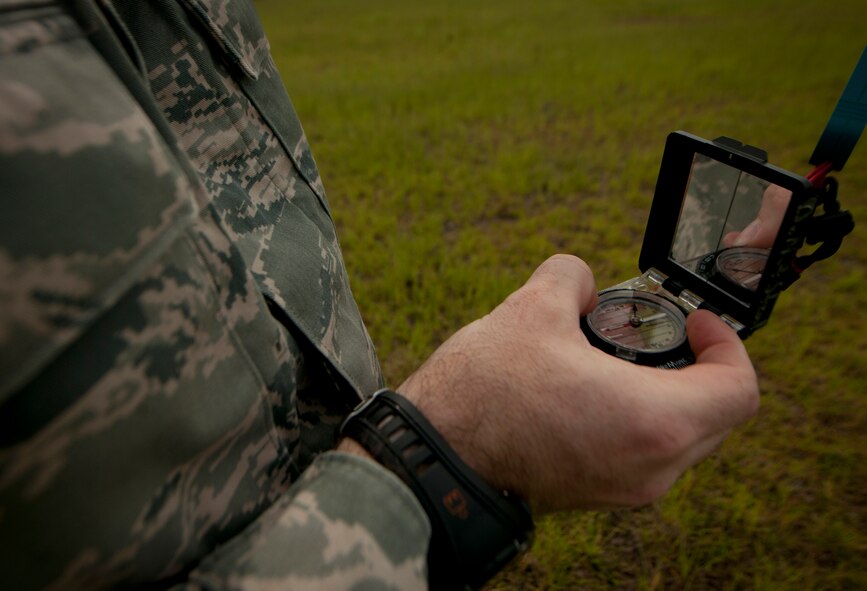 U.S. Air Force Tech. Sgt. Clayton Morris, 38th Rescue Squadron aircrew flight equipment NCO in charge, uses a compass to measure wind direction before a free fall jump at Moody Air Force Base, Ga., July 12, 2011. Wind direction indicates where the wind is coming from, not where it is going. An example of this is southerly wind blowing from the south to the north. (U.S. Air Force photo by Airman 1st Class Joshua Green/Released)
