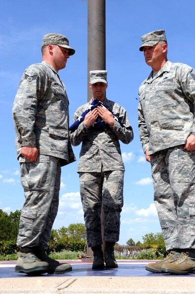 DYESS AIR FORCE BASE, Texas-- Dyess Honor Guardsmen (from left to right) Senior Airman Zachary Montgomery, Staff Sgt. Brandon Hutchinson and Master Sgt. Christopher Ellis retire the colors during a retreat ceremony held at the parade grounds here July 15, 2011. A retreat ceremony signifies the end of a duty day. (U.S. Air Force photo by Airman 1st Class Courtney Moses/Released) 