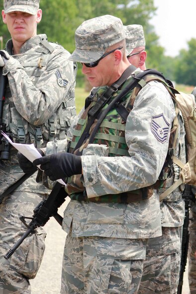 Master Sgt. Thomas Robelia reads a map as Senior Airman Brett Milbrandt looks on. (Air Force Photo/Master Sgt. Nicollette Shegstad)
