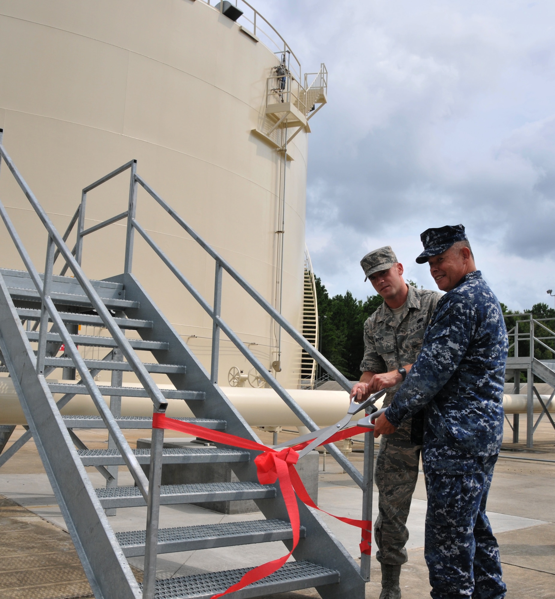 Airman 1st Class Houston Boyd and Cmdr. Charles Phillip cut the ribbon reopening fuel tank five July 15 at Joint Base Charleston - Air Base. The fuel tank has been under refurbishment since January 2007 due to a faulty floating pan, but is now fully functional. Boyd is a 628th Logistics Readiness Squadron Fuel apprentice and Phillip is the 628th Mission Support Group executive officer. (U.S. Air Force photo/ Airman 1st Class Jared Trimarchi)

