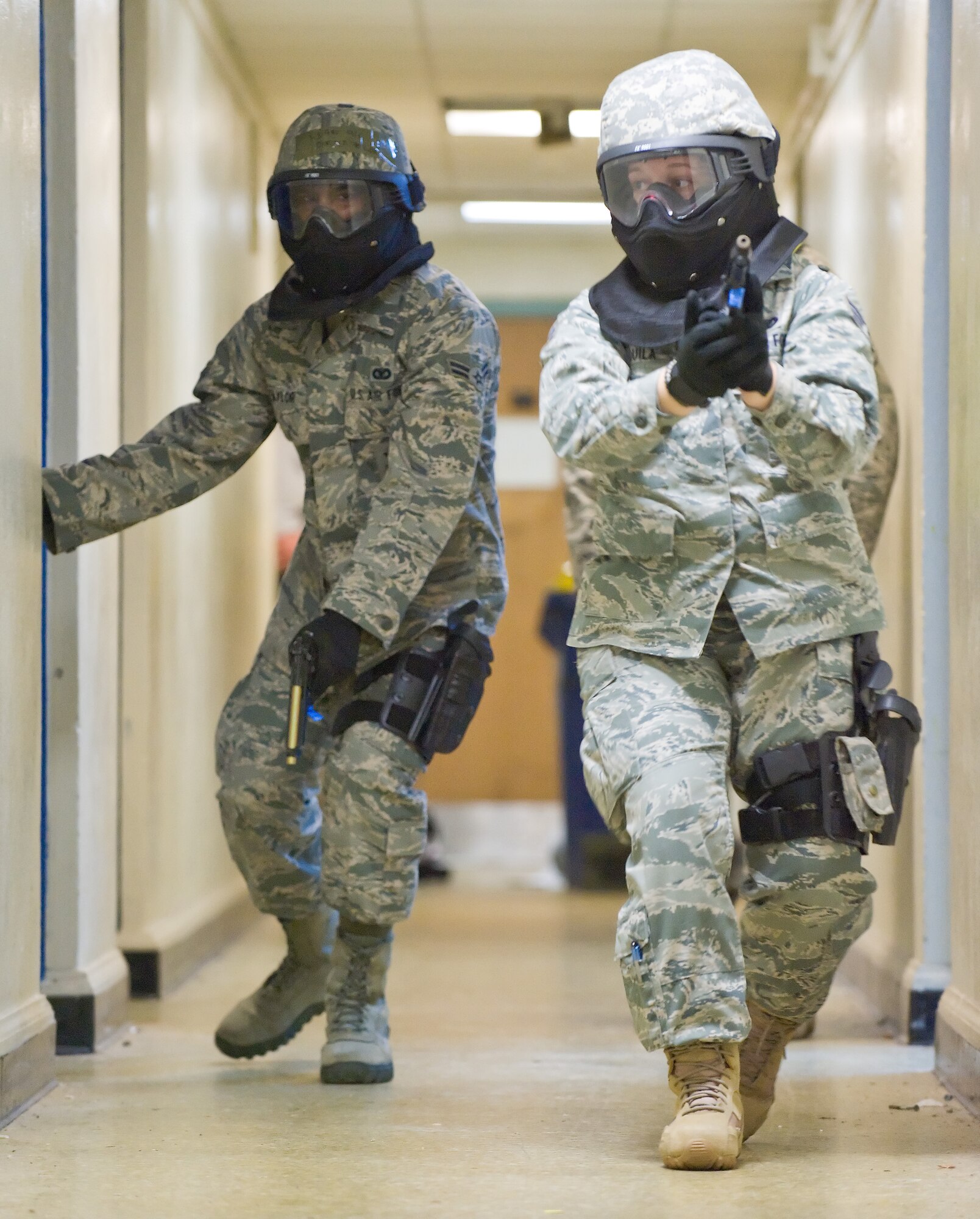 Airman 1st Class Damien Taylor (left) and Senior Airman Amanda Aquilla, both with the 436th Security Forces Squadron, storm the halls looking for an active shooter during an exercise July 14, 2011, at Wesley College in Dover, Del.  The exercise was a joint exercise between 436 SFS and the Dover Police Department. (U.S. Air Force photo by Roland Balik)