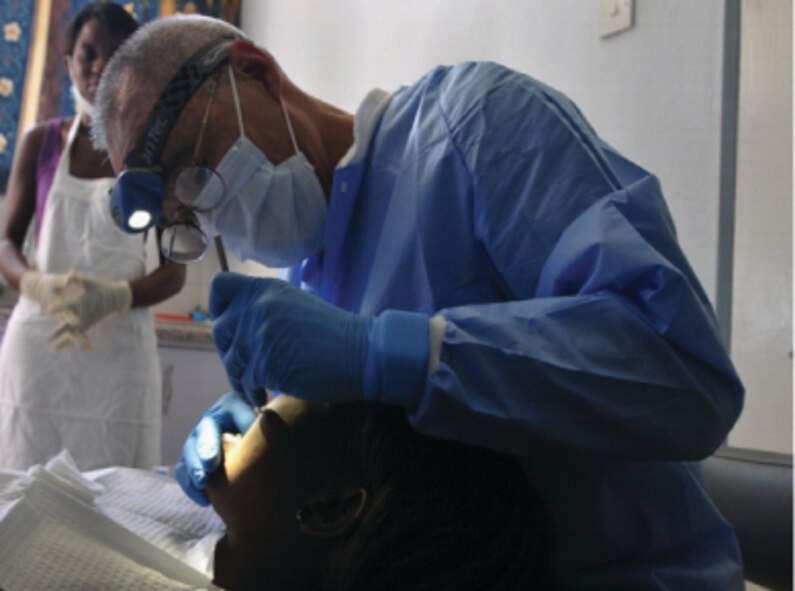 LILONGWE, Malawi - Col. Sheldon “Shel” Omi, dental officer in charge of MEDREACH 11 and commander of the 302nd Aeromedical Staging Squadron, Peterson Air Force Base, Colo., performs a dental procedure on a Malawian patient May 6, 2011.  (Courtesy photo)